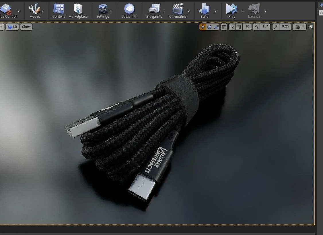 Black braided USB-C charging cable with Velux branding, wrapped in a black strap, on a dark surface.