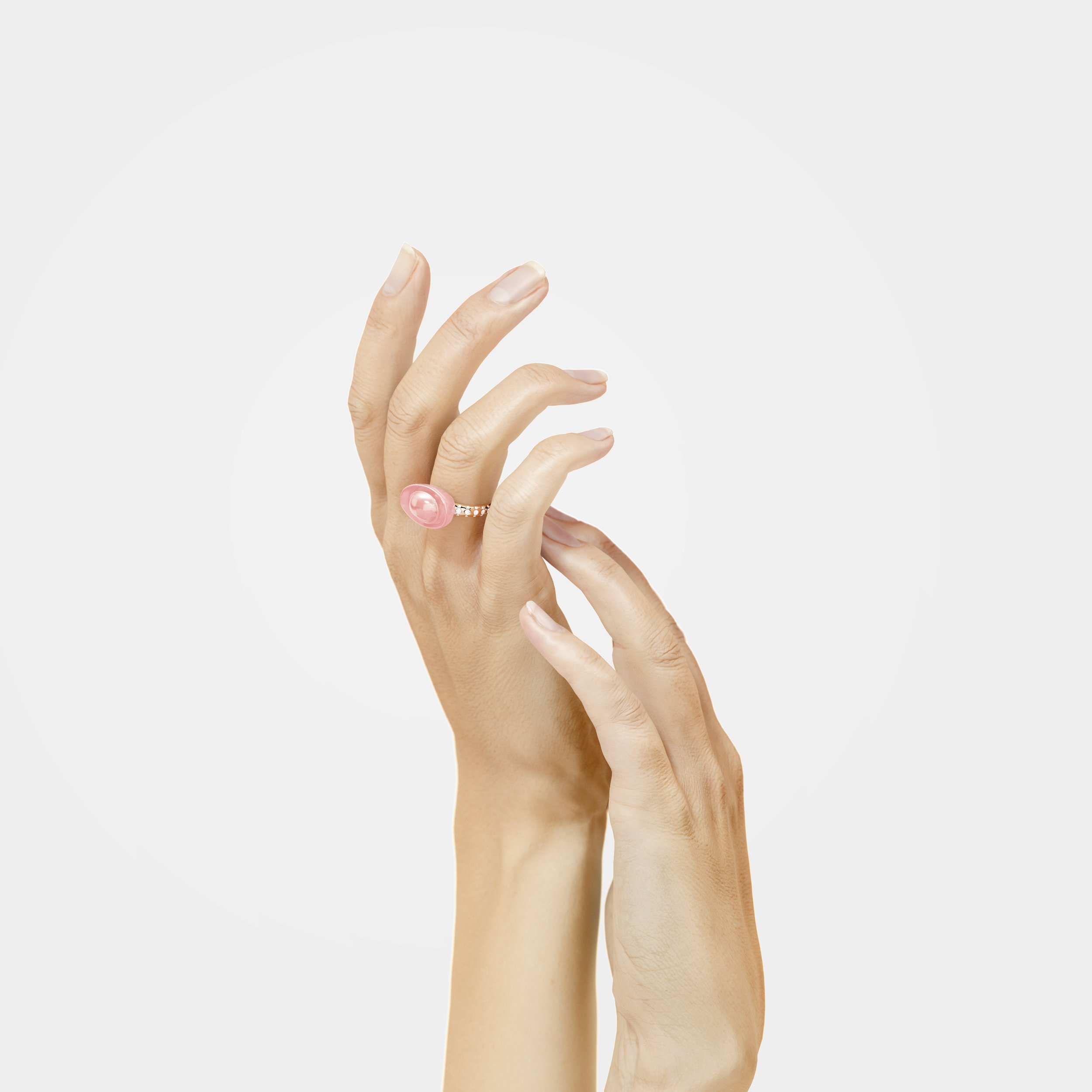 Close-up of a hand with a pink ring on the middle finger, shown against a plain white background.