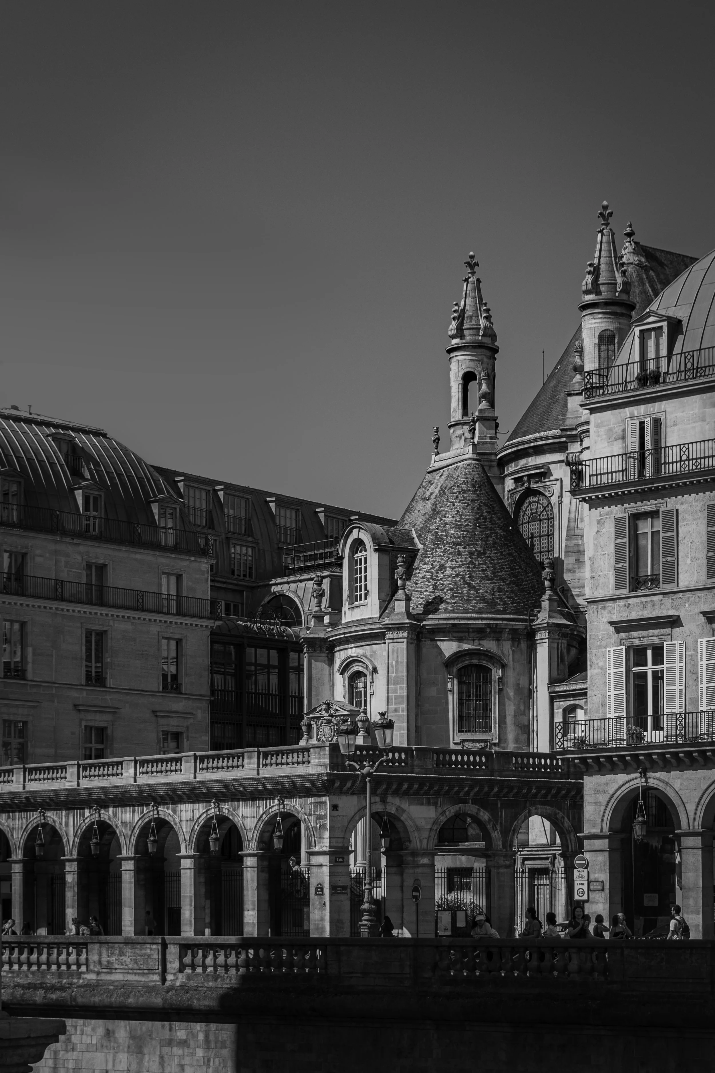 Black and white photo of historic European buildings with ornate architecture, domes, towers, and arched windows.