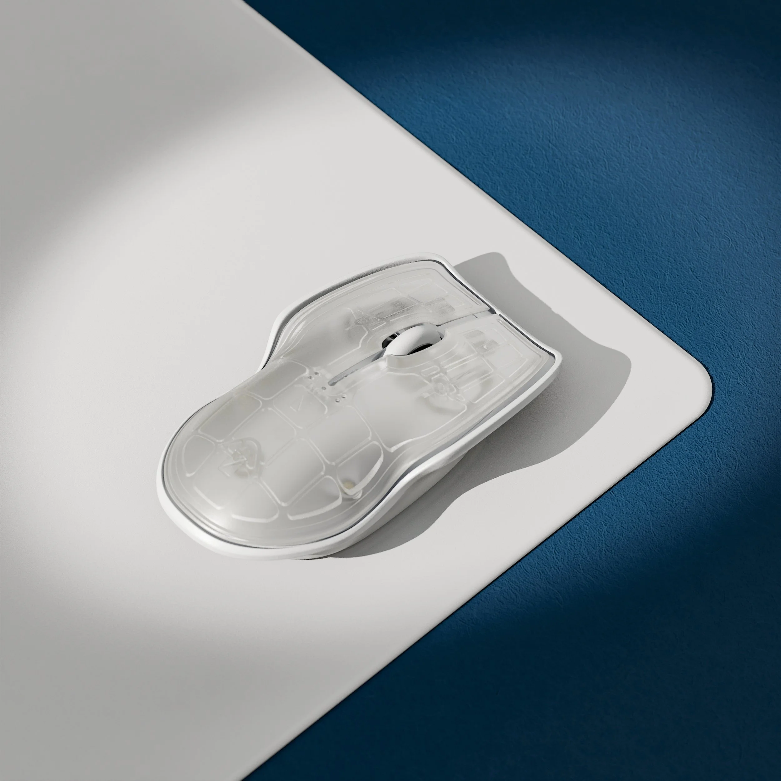 Lunar Artefacts  Computer mouse with transparent shell on white and blue desk surface.