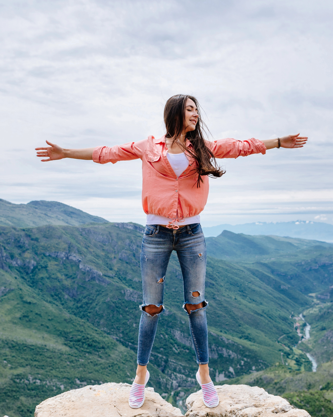 Woman standing on a mountain symbolising strength, self-love and inner balance – Luna Charms Ireland