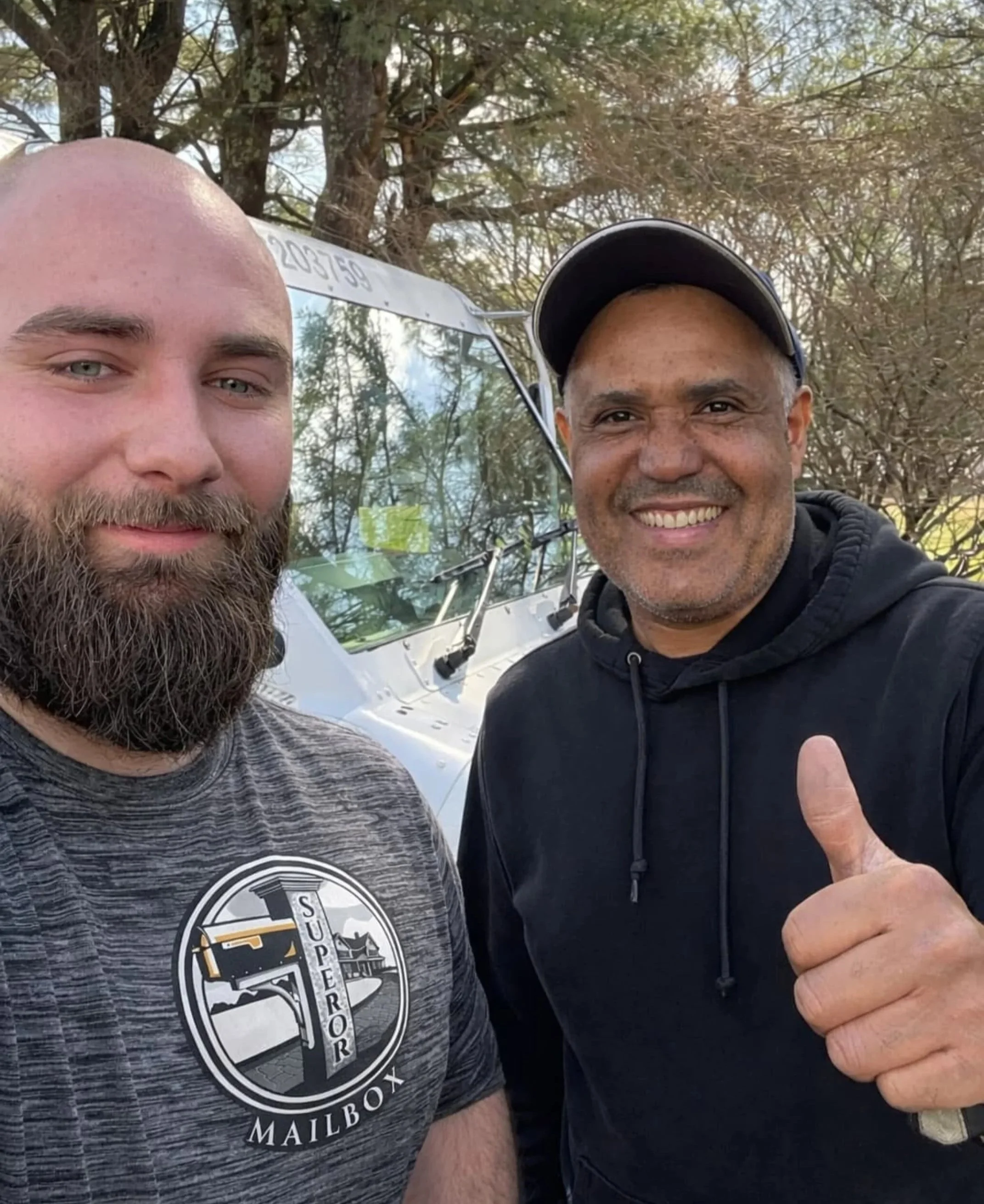 Colton standing next to a man giving the thumbs-up sign