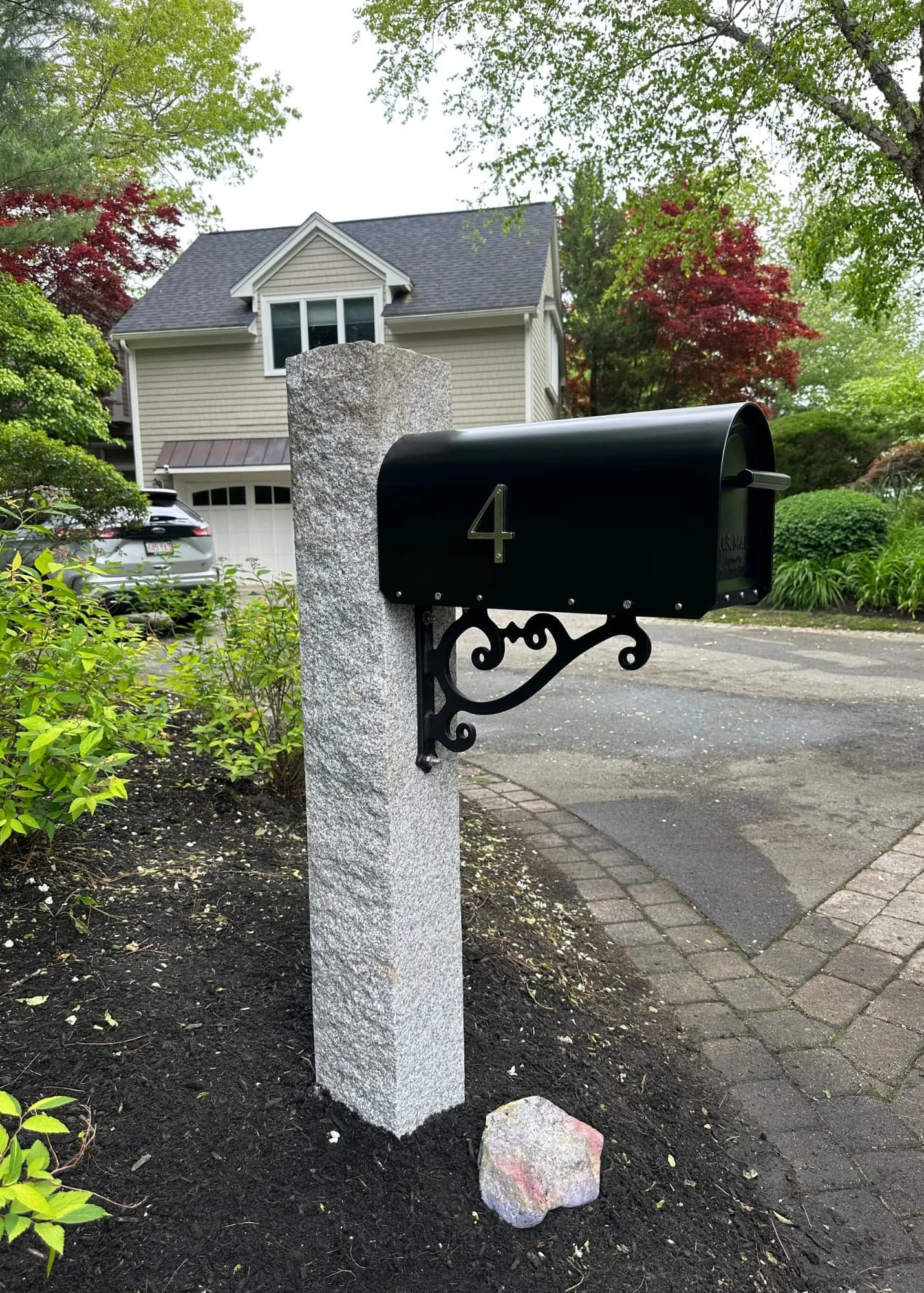 granite post, natural cap, black mailbox, modern scroll bracket