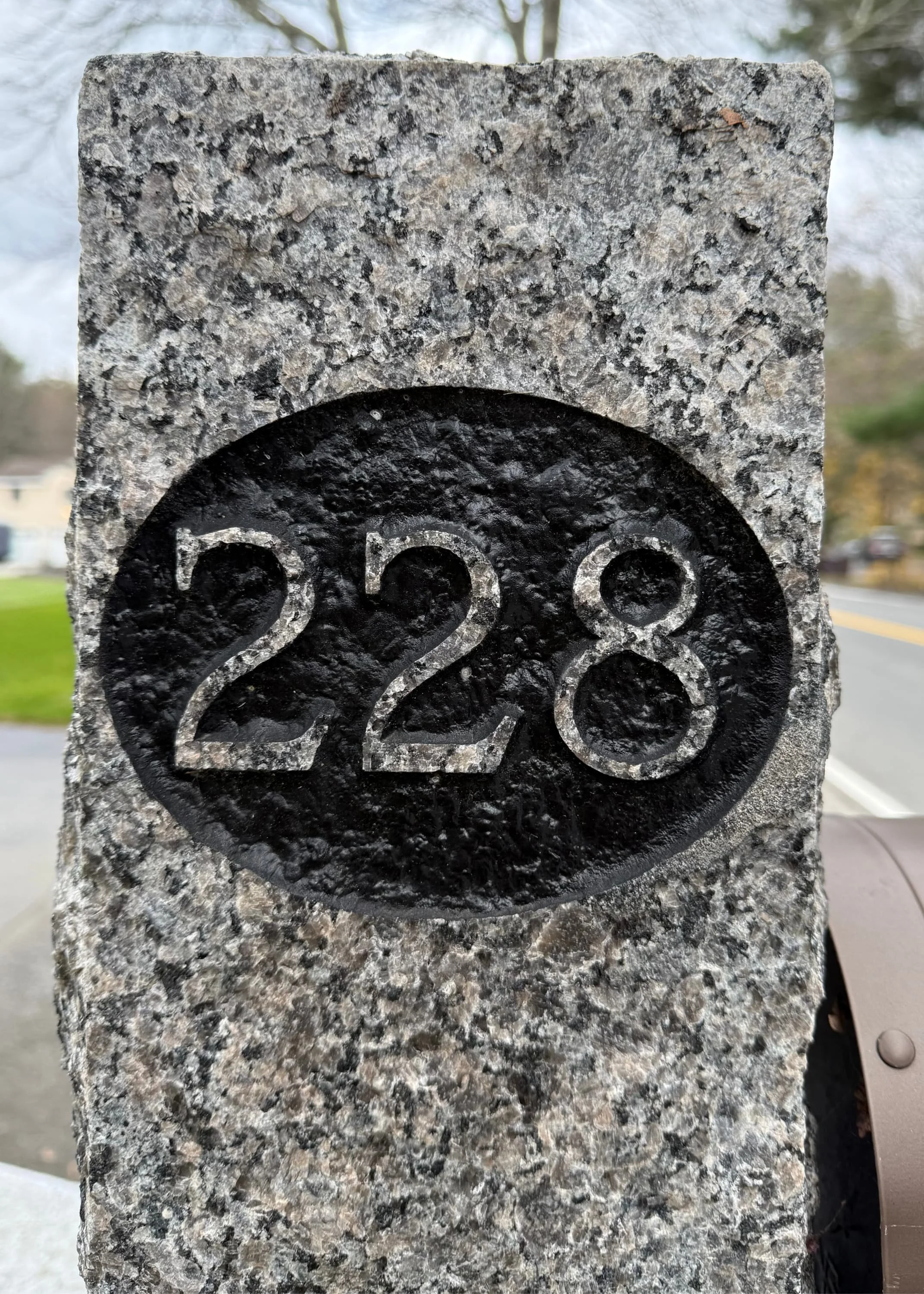 close-up of reverse-style engraving on granite post with numbers 228