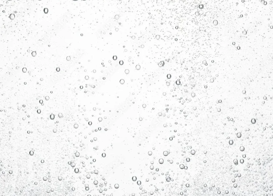 Bubbles floating in a liquid, appearing as a pattern of small circles on a light background.