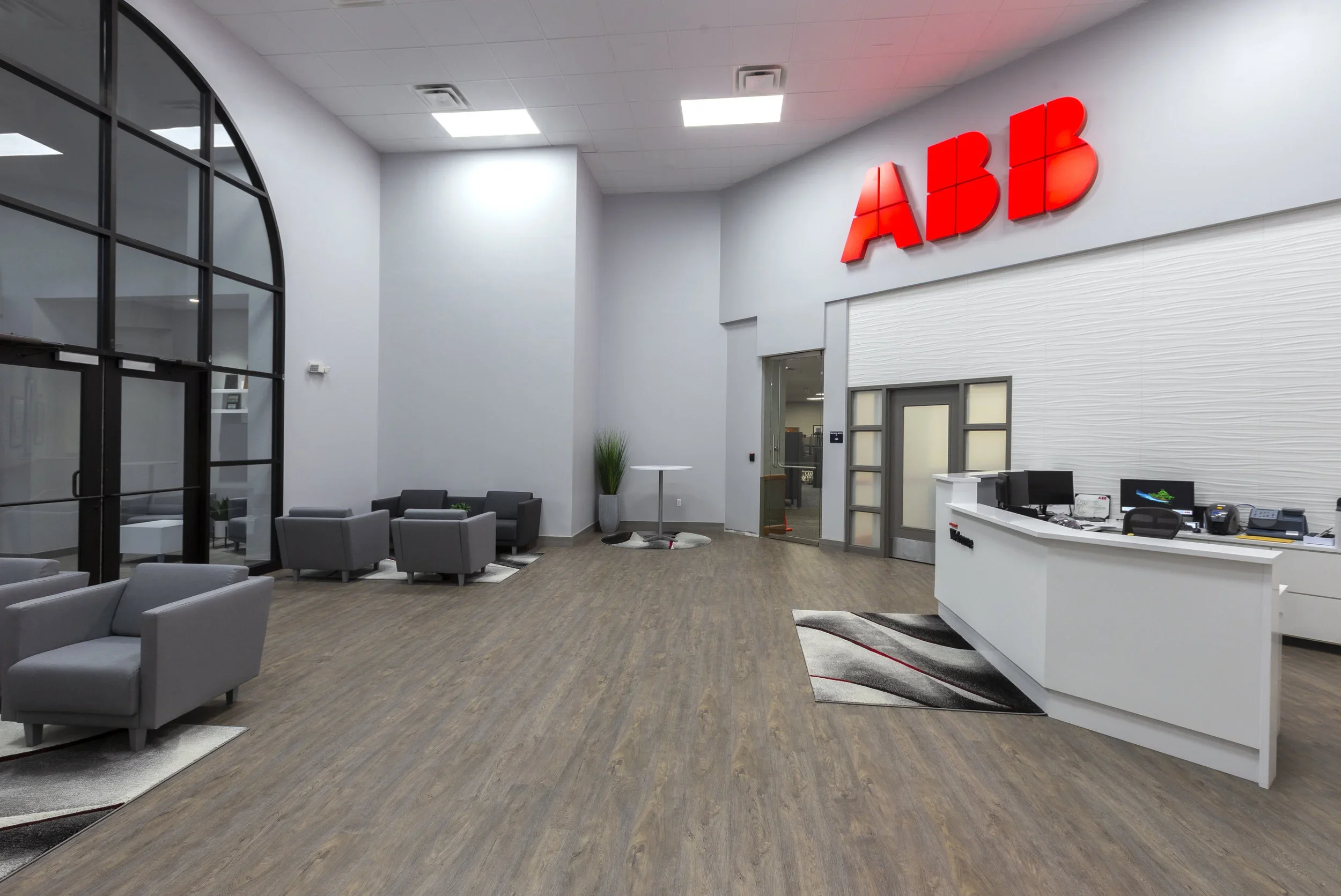 Modern office lobby with seating area, reception desk, and large red illuminated 