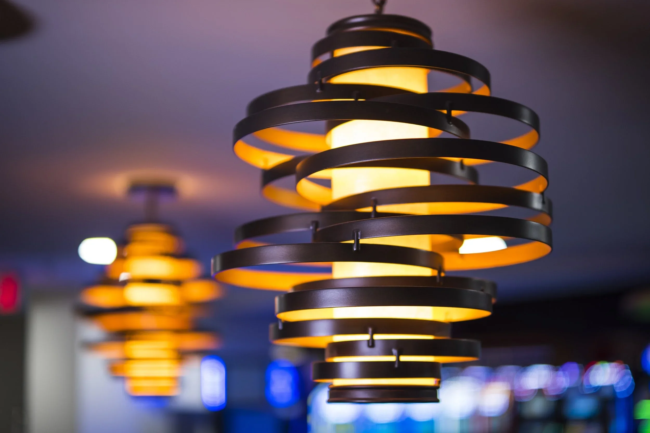 Modern pendant lights with spiral design in a dimly lit interior.