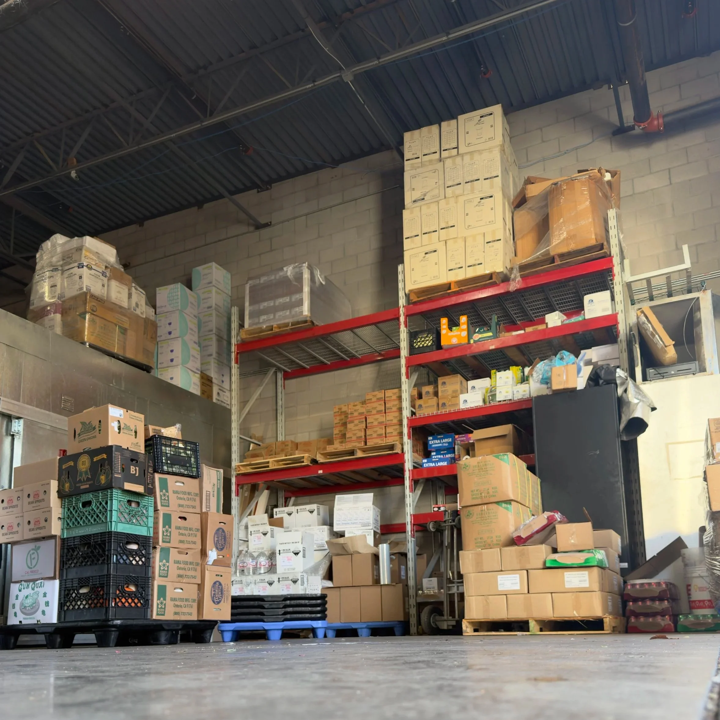 Storage shelves filled with boxes and pallets in a warehouse.