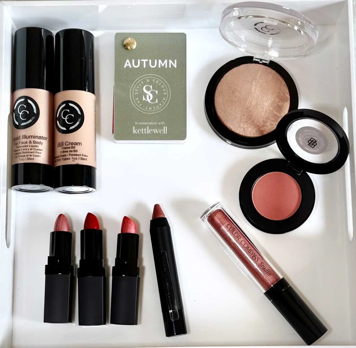 Autumn color palette makeup including warm neutral lipsticks, blush, bronzer, BB cream, and an Autumn color swatch card at Color Compass Studio, Kansas City