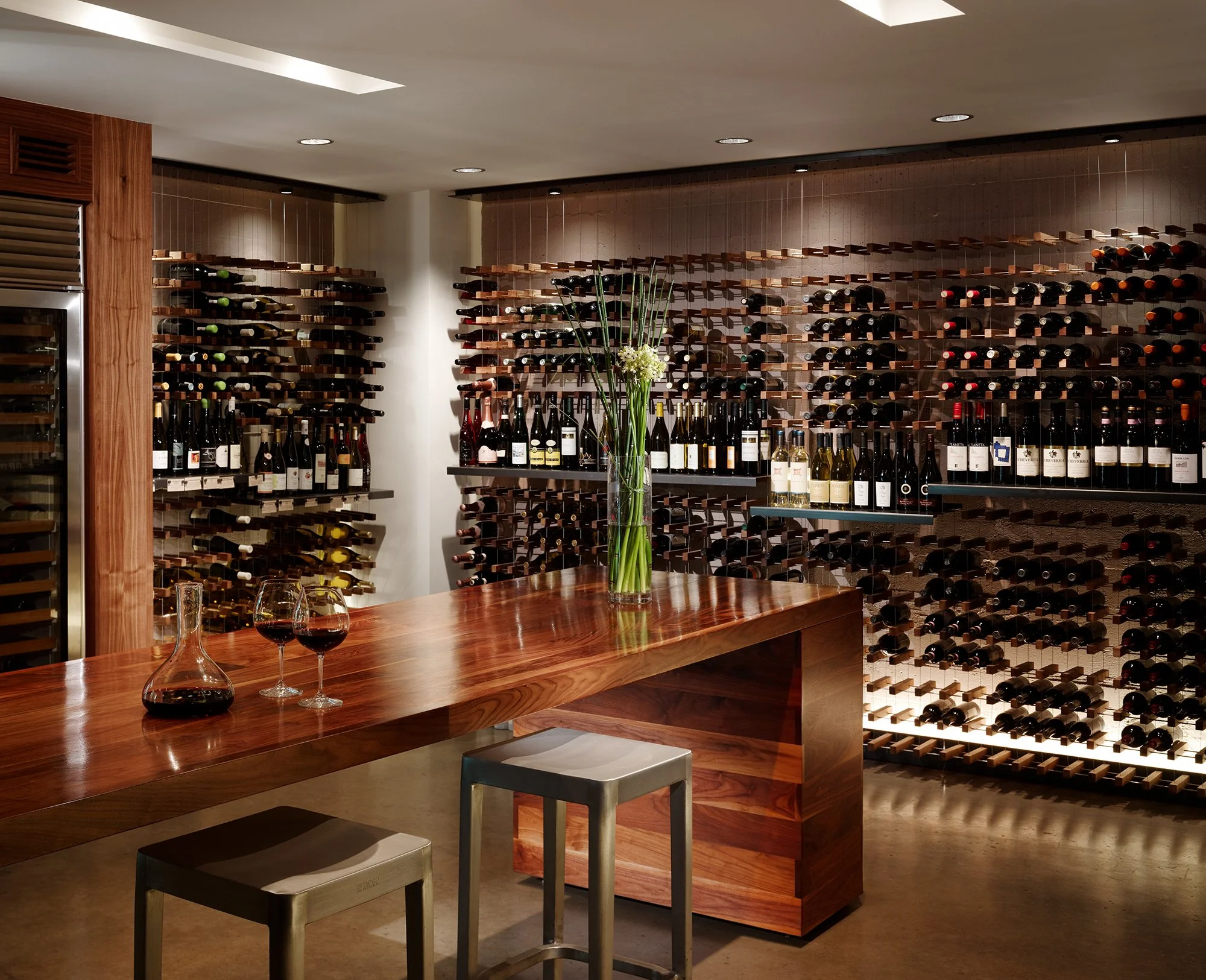 Local Wine Merchant restaurant and bar in San Francisco. Everything custom fabricated. Interior view of wine rack and bar table with warm wood.