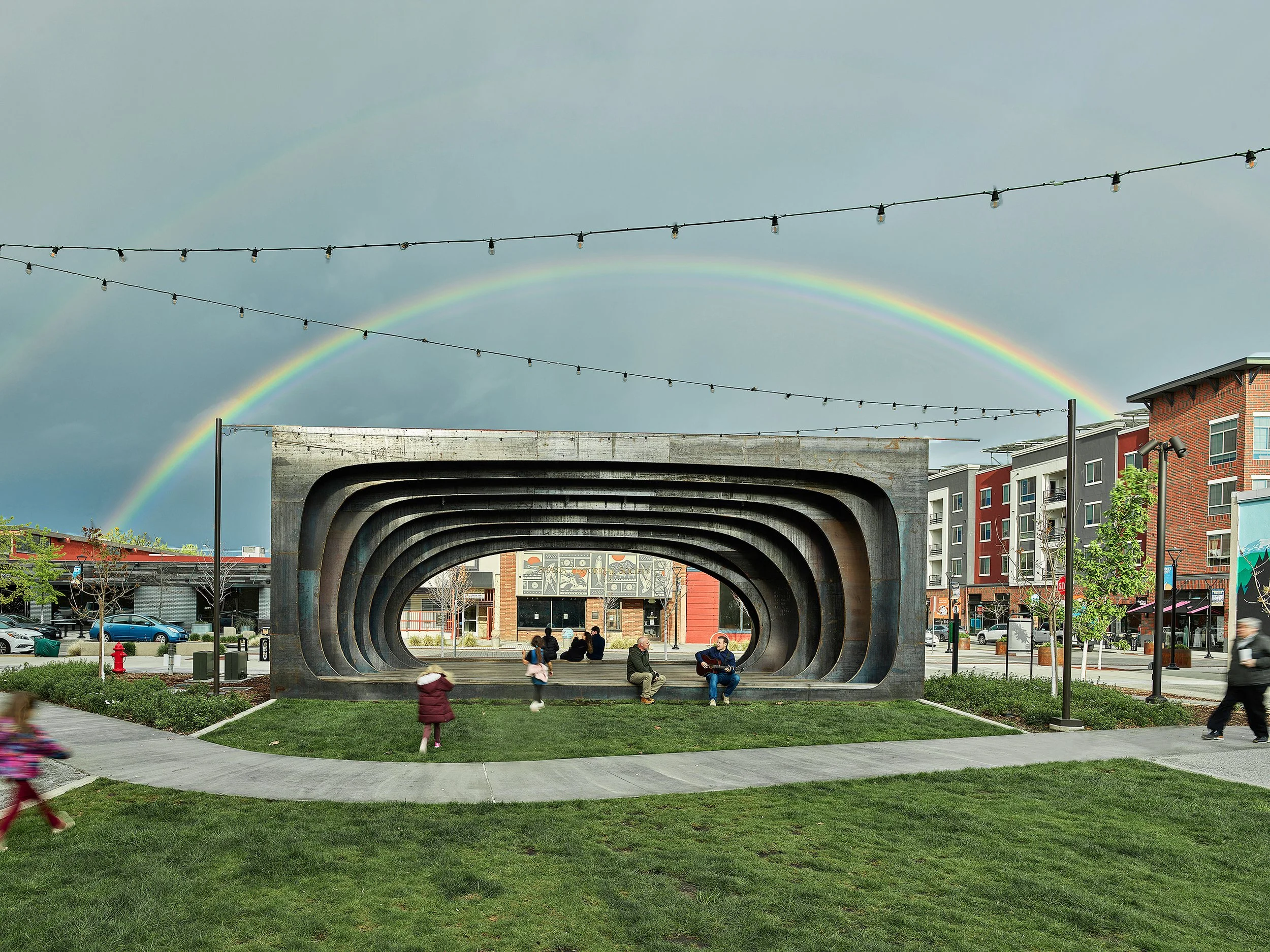 Block 7 Development in Redding, California. Whistle Stop Park custom steel pavilion. People sitting and walking in an urban park