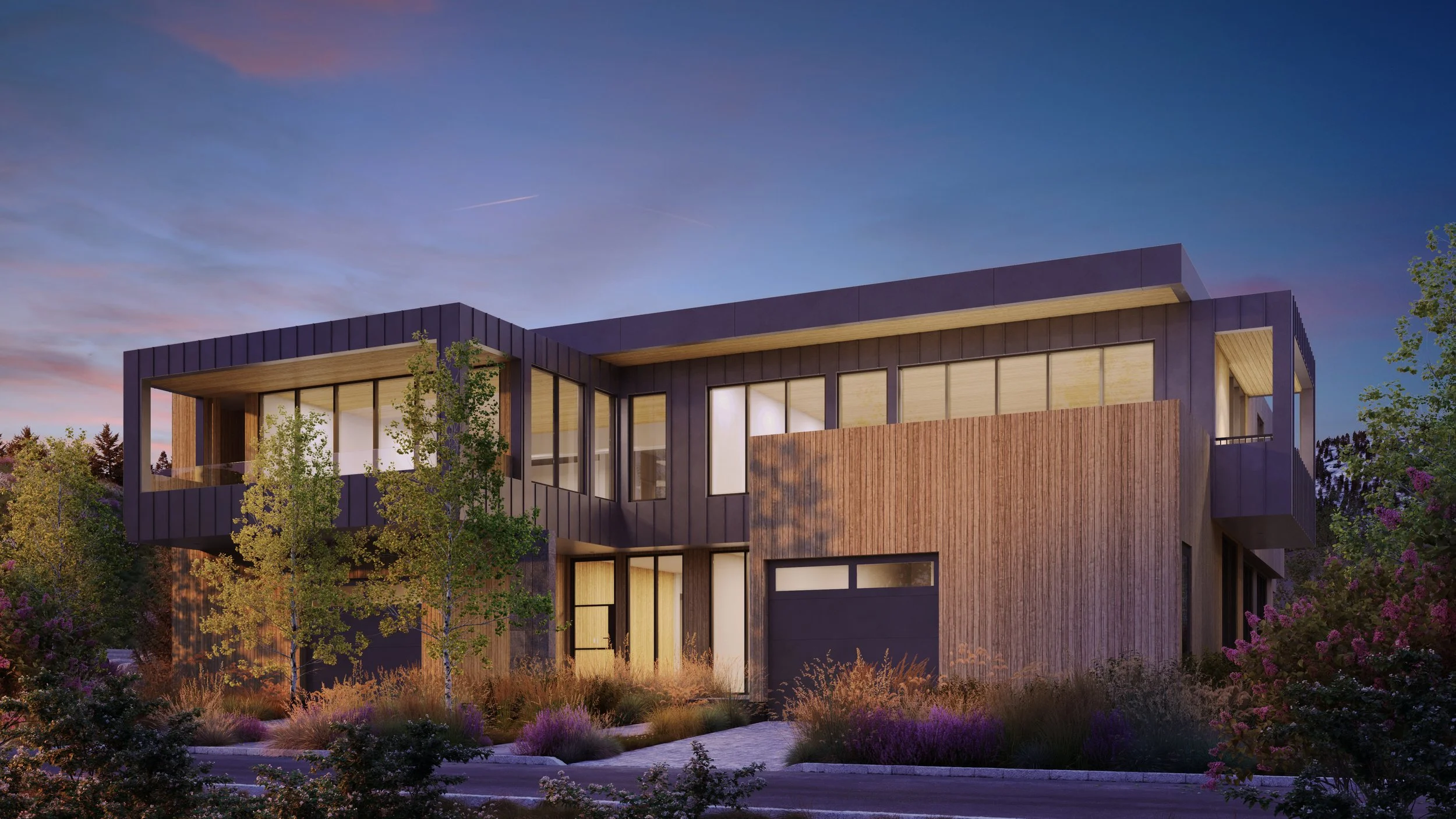 Jackson Development in Jackson, Wyoming. Modern multi-story house with wooden and dark panel exterior, large windows, surrounded by trees and shrubs, during sunset.