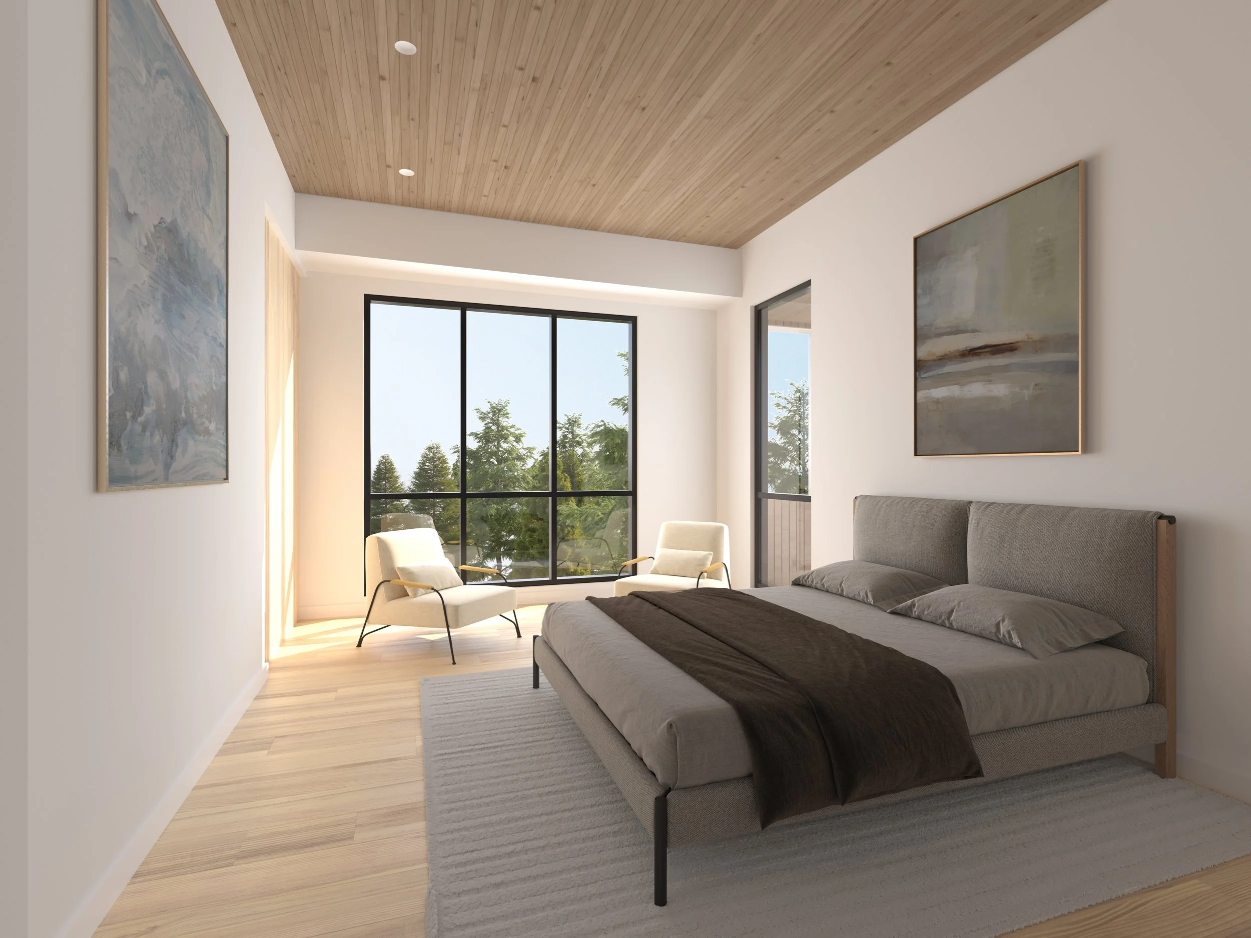 Jackson Development in Jackson, Wyoming. Modern bedroom with a large bed, two white armchairs, large windows showing trees outside, and artwork on the walls.