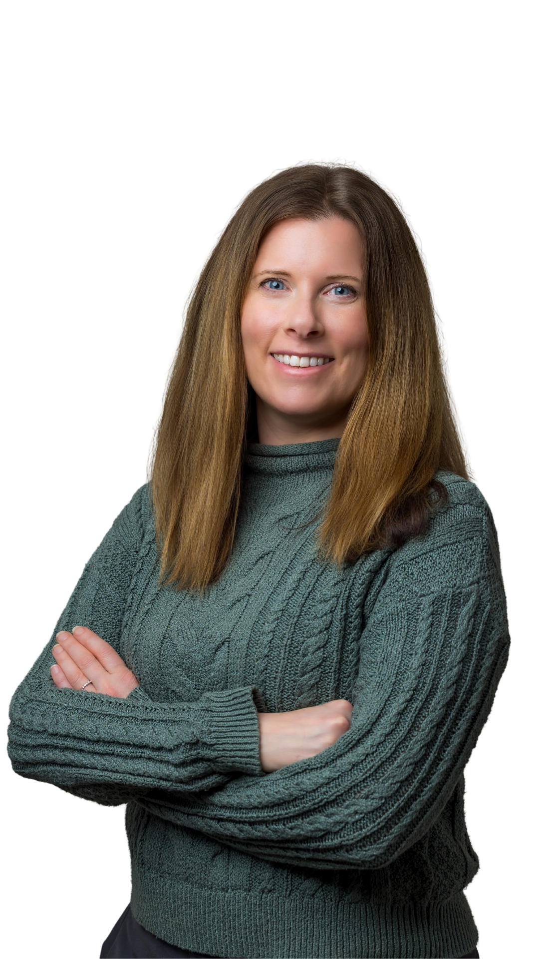 A woman with long, straight brown hair, blue eyes, and light skin, smiling and crossing her arms, wearing a dark green knitted sweater against a black background.