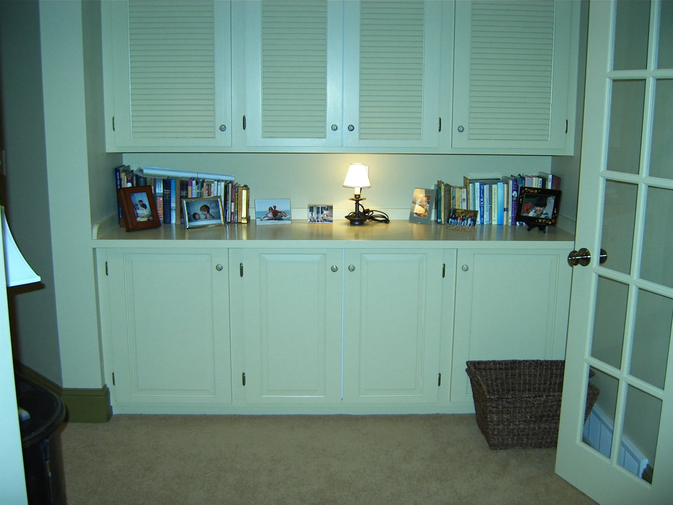 Custom  built-in white storage cabinets and louvered doors