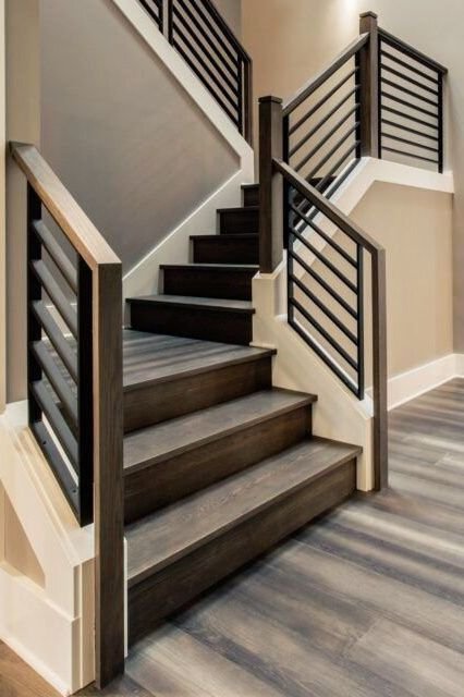 Interior staircase with dark wooden steps and black metal railings