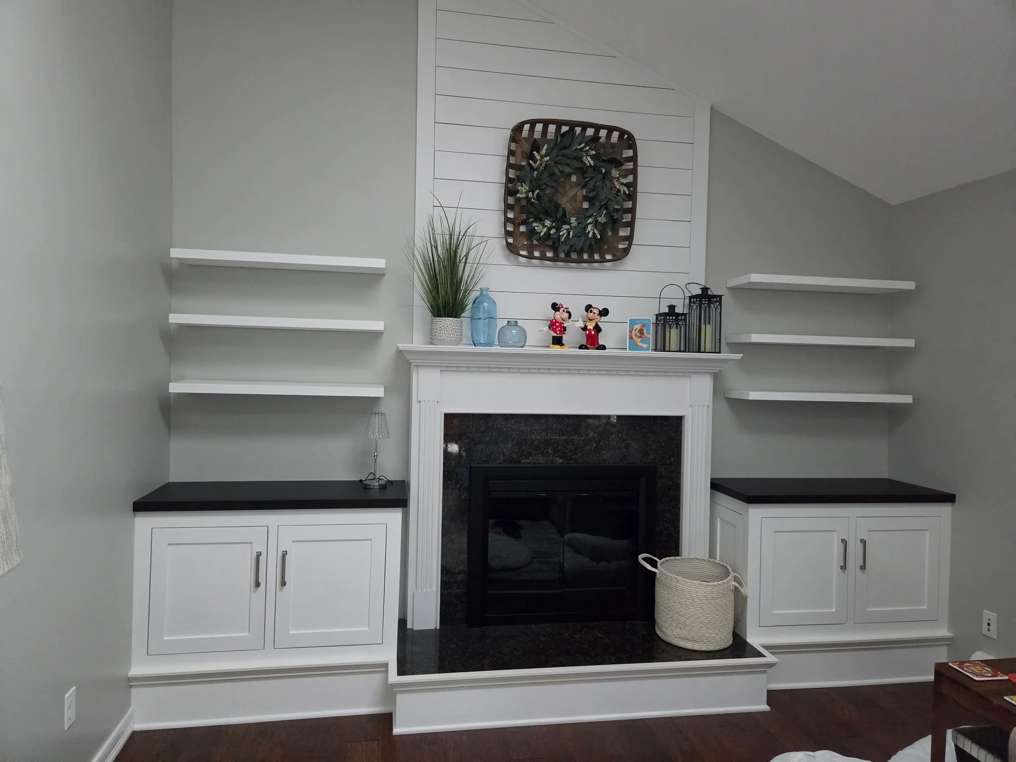 needed storage - inset hinges on doors, base same height as hearth ..six floating shelves ..black cabinet tops , matching fireplace and marble top of hearth