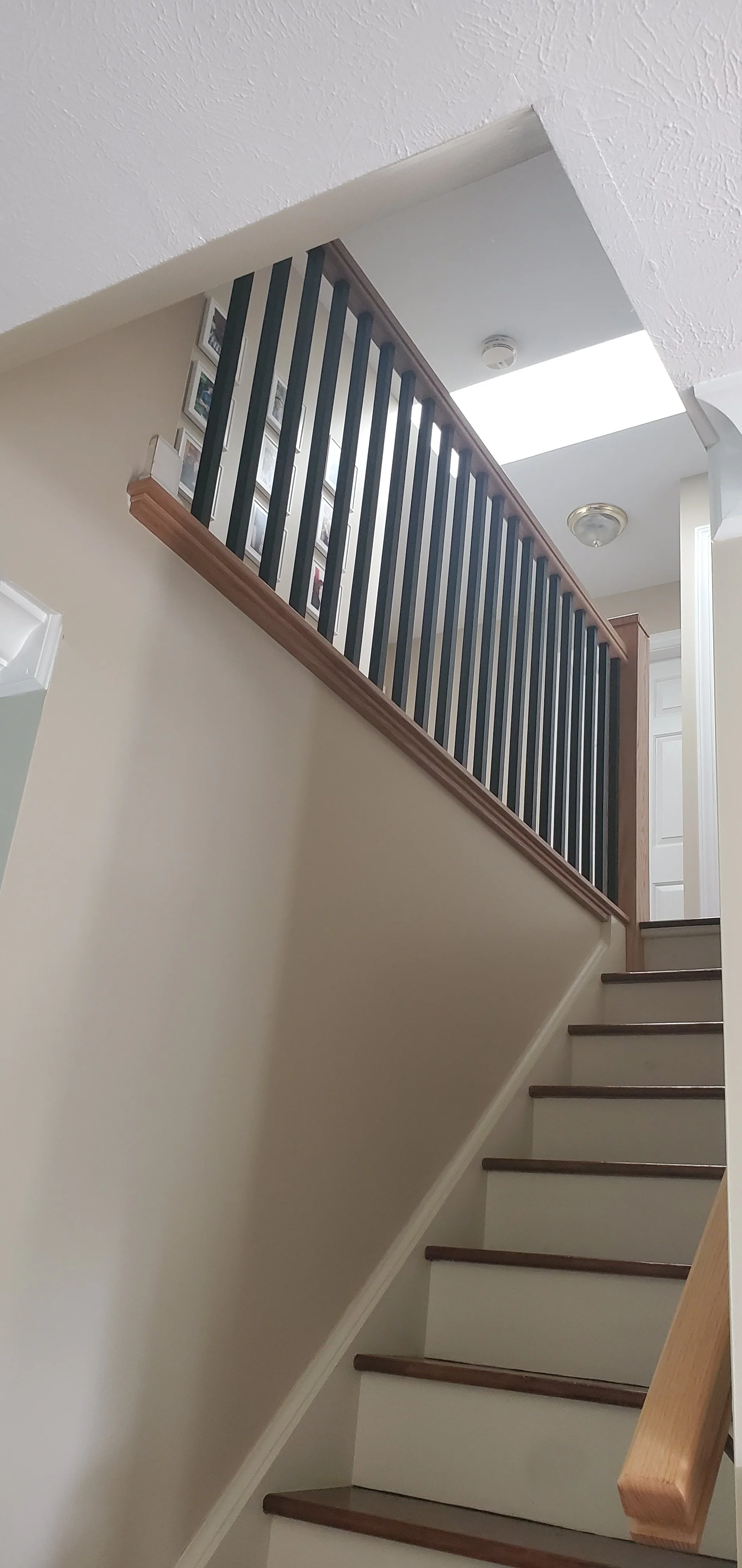  staircase redesigned rail with Oak rail and 1"x1" square spindles, oak treads sanded and restained 
