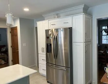 Kitchen with white cabinetry, stainless steel refrigerator, and light blue walls.
