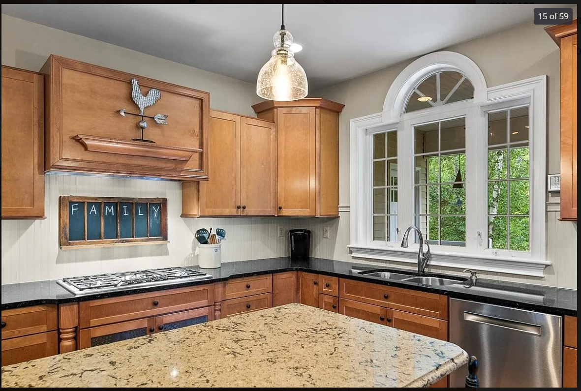 White wainscoting on a wall with a framed artwork above, and a wooden floor with a decorative vent cover on the floor.