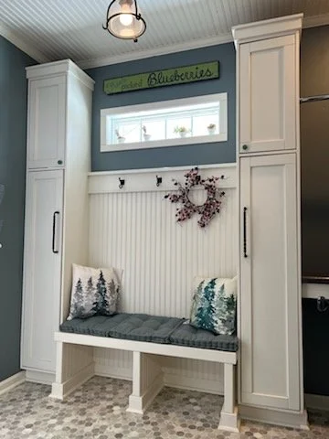 Mudroom with custom built-in bench, white cabinets, decorative pillows, wainscot ceiling and new flooring, a window to add light.