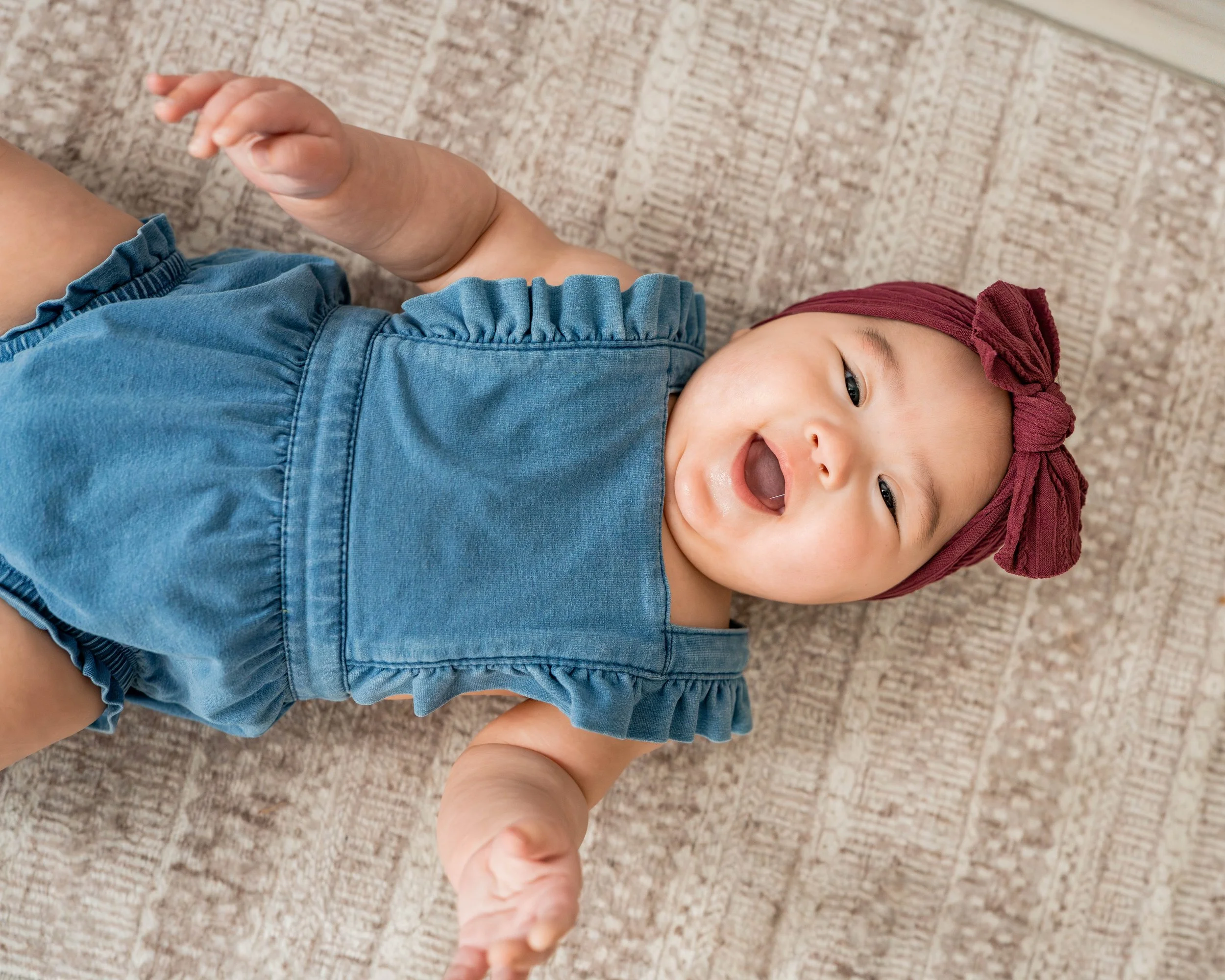 Baby girl laying down with a big smile