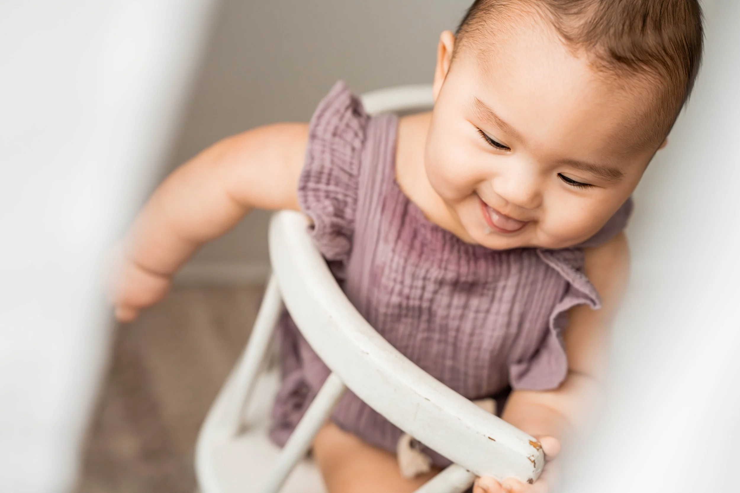 Baby girl in a purple outfit smiling