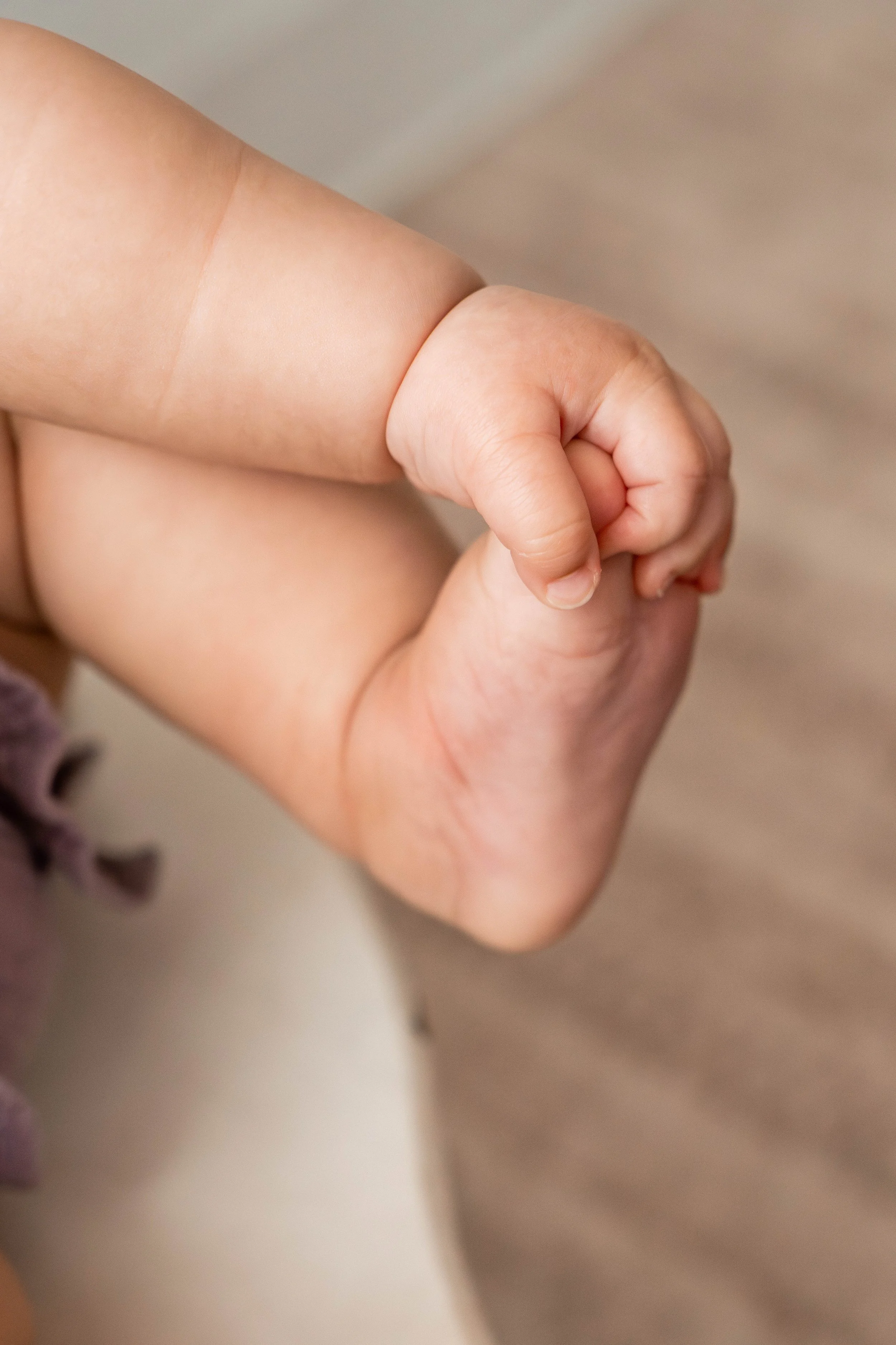 Baby girl grabbing her toes during her 6-month studio milestone session in Beavercreek, Ohio