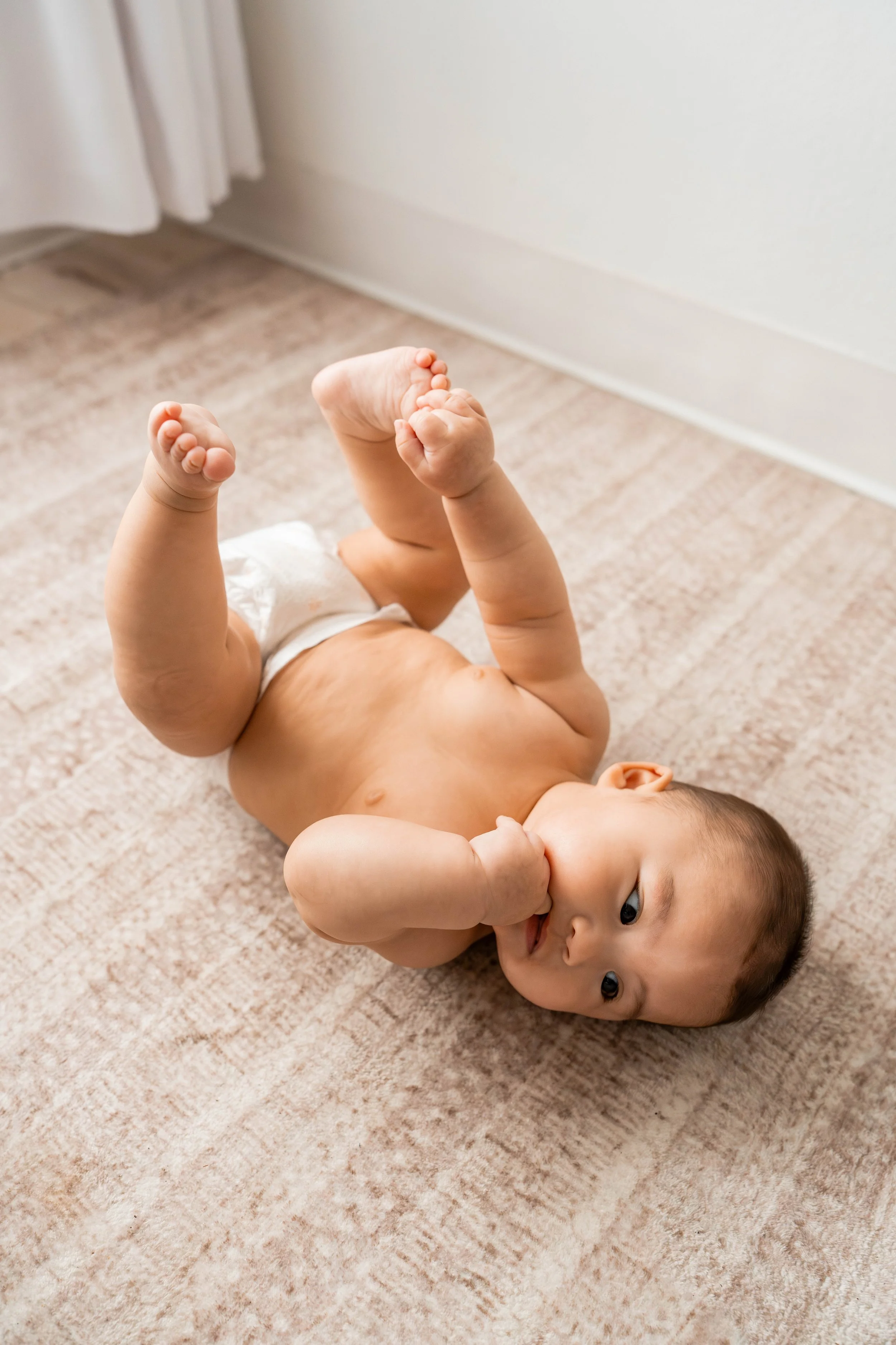 Baby girl laying on the floor in her diaper