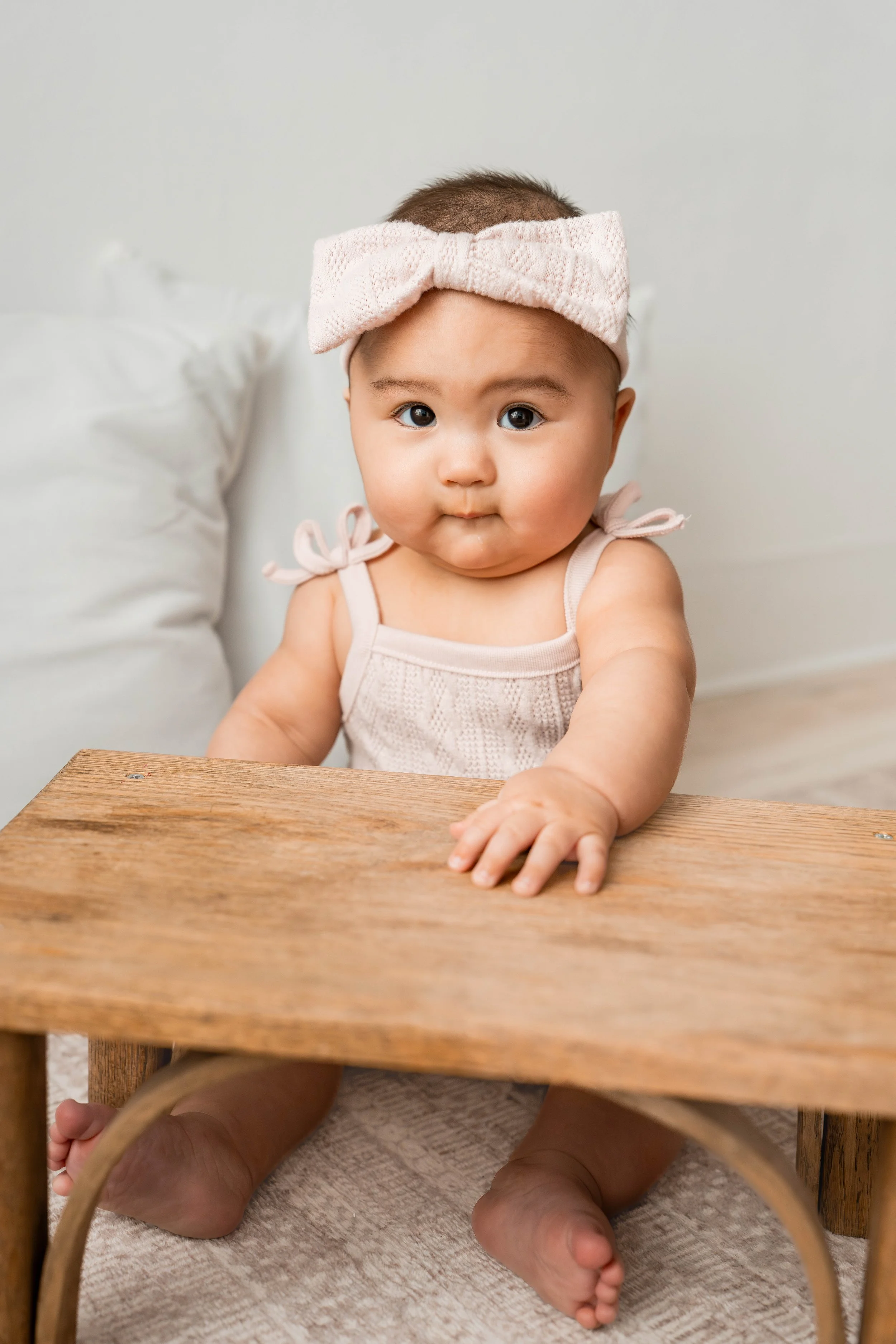 Baby girl looking at the camera in a pink bow during her 6-month studio milestone session in Beavercreek, Ohio