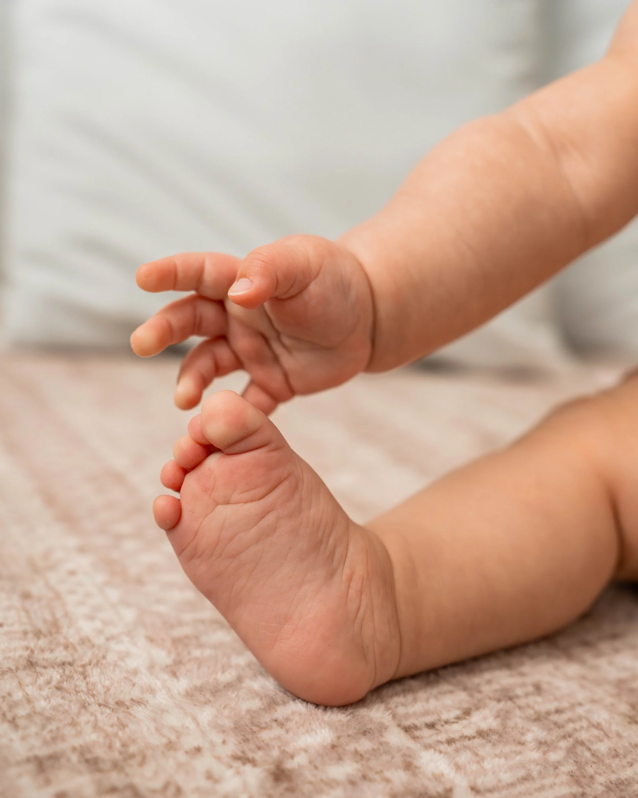 Baby girl grabbing her toes