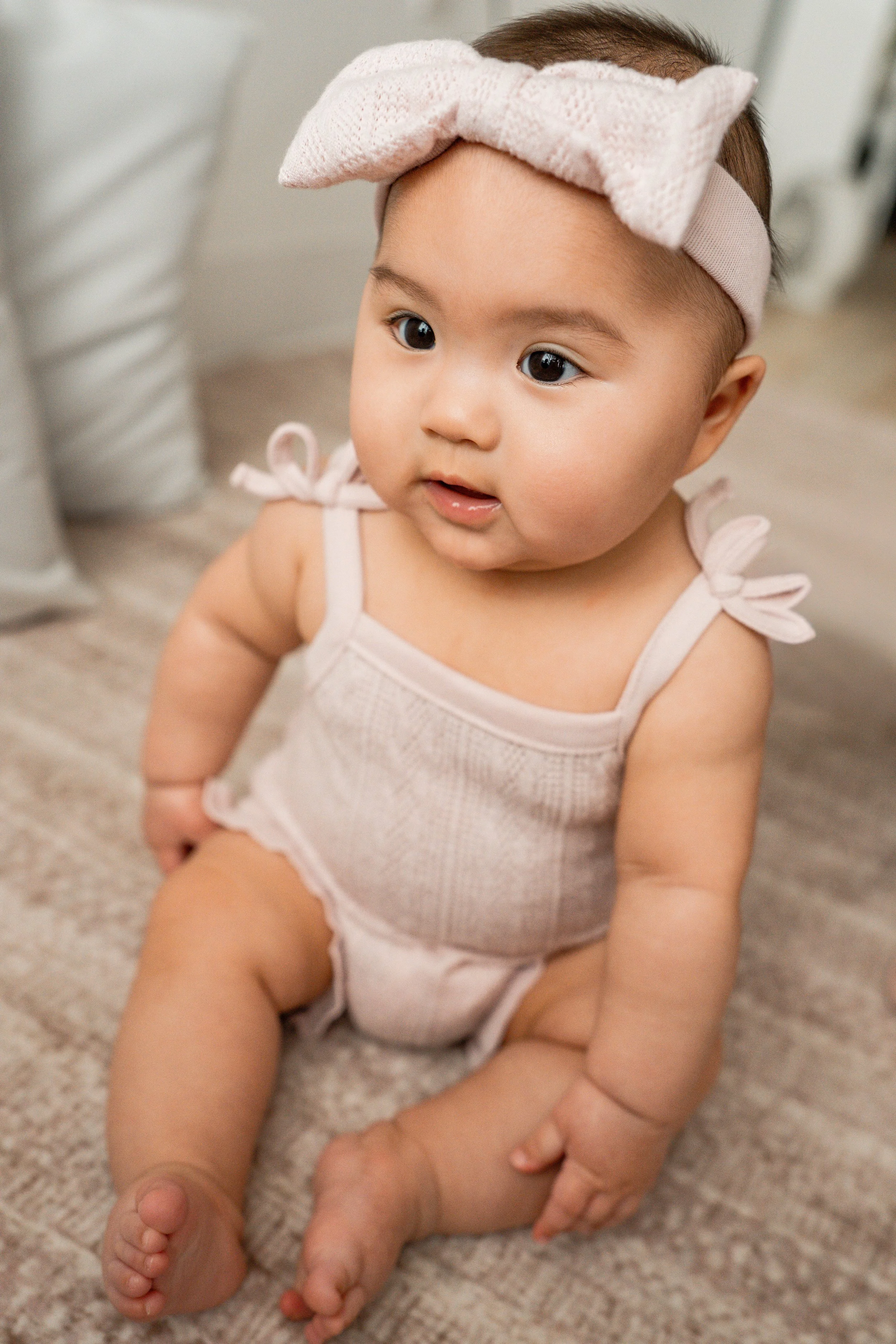 Cute baby girl in a pink bow during her 6-month studio milestone session in Beavercreek, Ohio