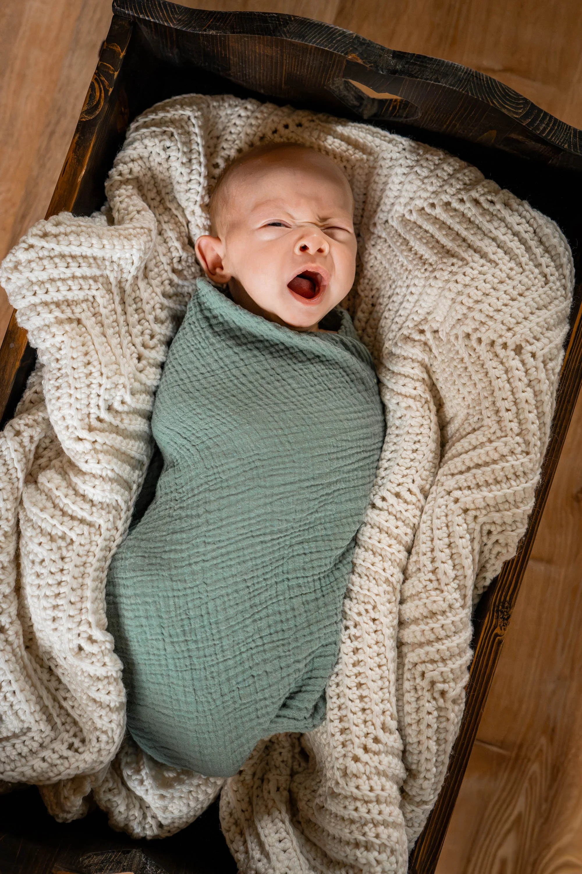 baby in a cradle yawning in his Beavercreek Ohio home
