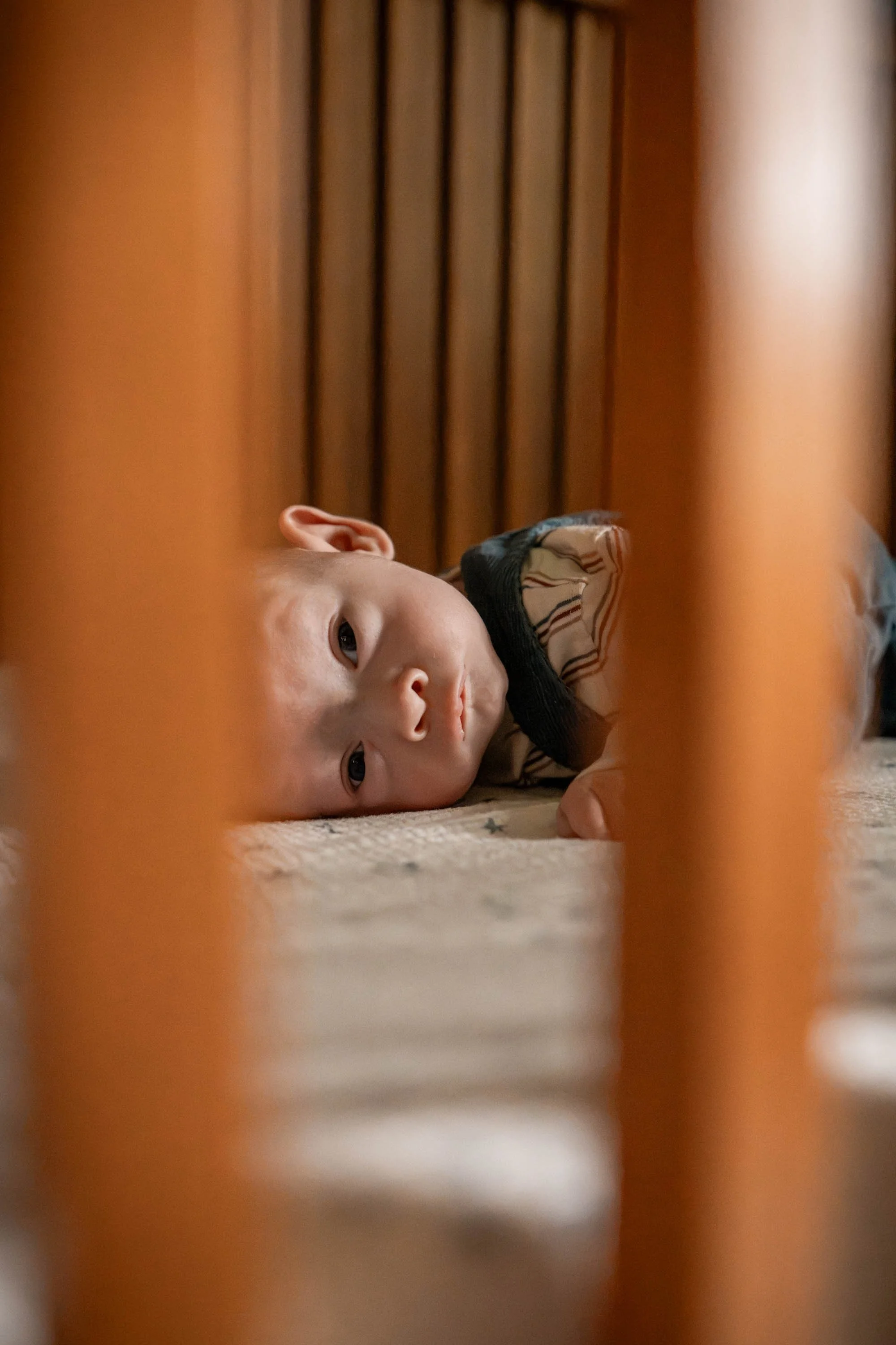 Beavercreek Ohio baby smiling through the side of the crib