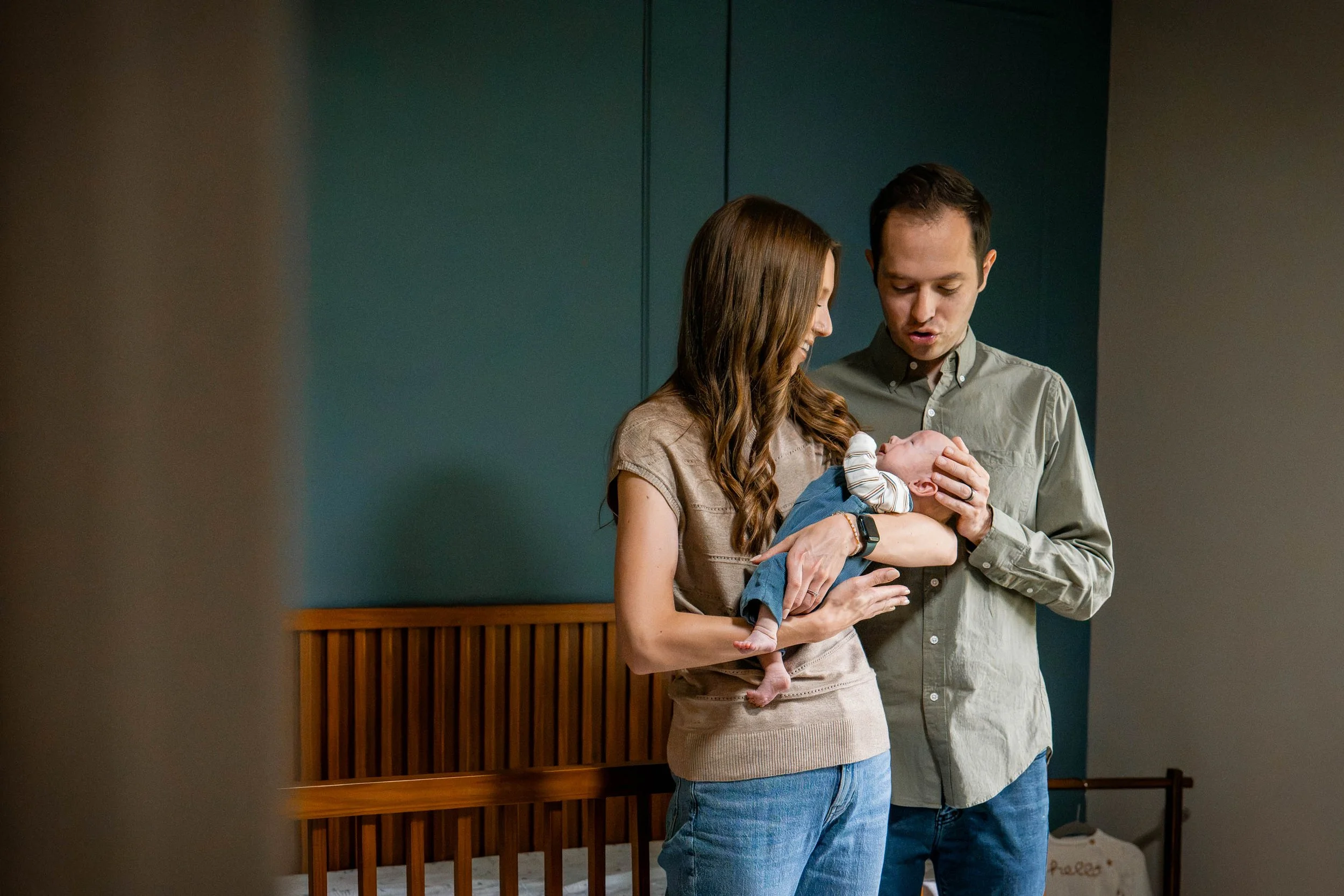New parents holding baby in nursery