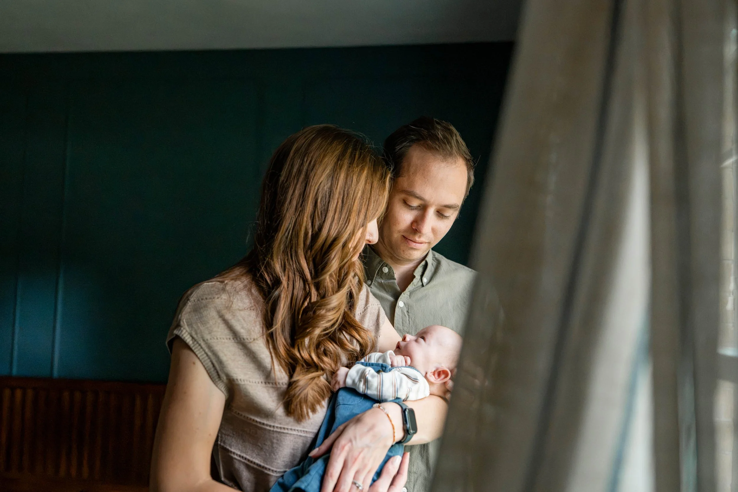`Newborn baby boy swaddled in green during in-home session in Beavercreek, Ohio