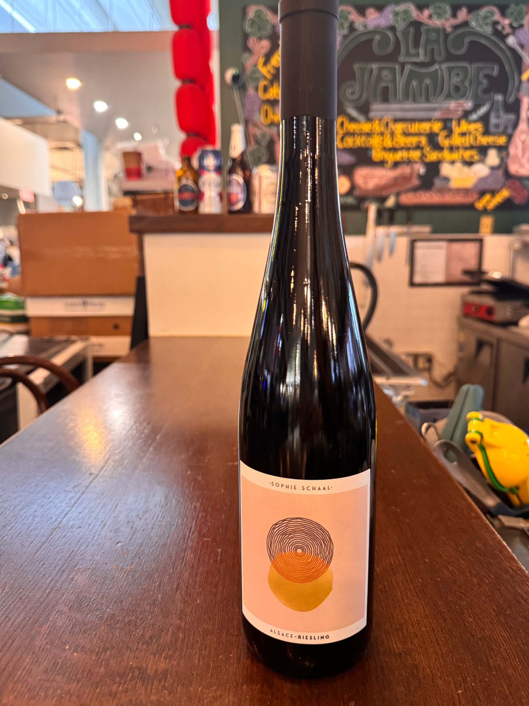 Bottle of Alsace Riesling wine with a minimalist label featuring a circular design and the names Sophie Schaal and Alsace Riesling.