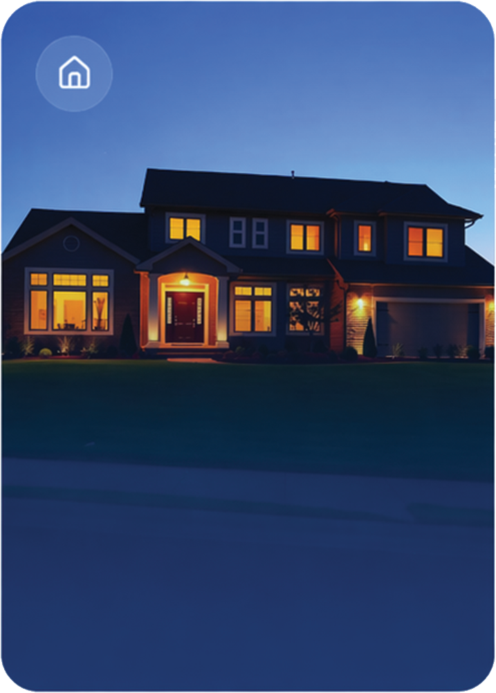 A two-story house illuminated with warm exterior lights during dusk or early evening.