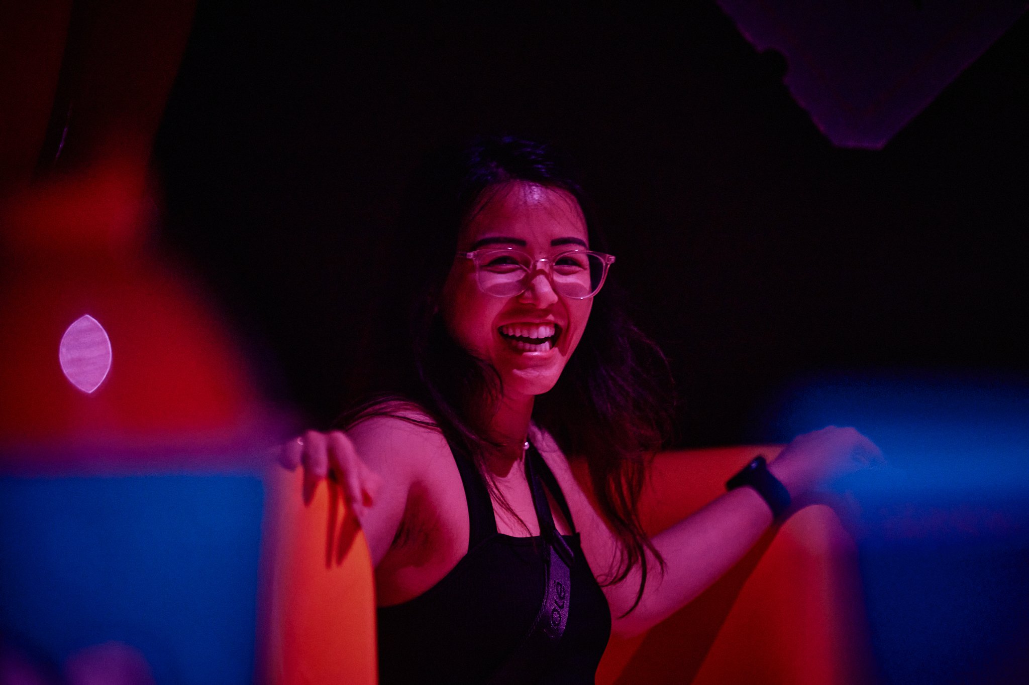 A woman laughing while sitting in a themed chair inside Atlas9