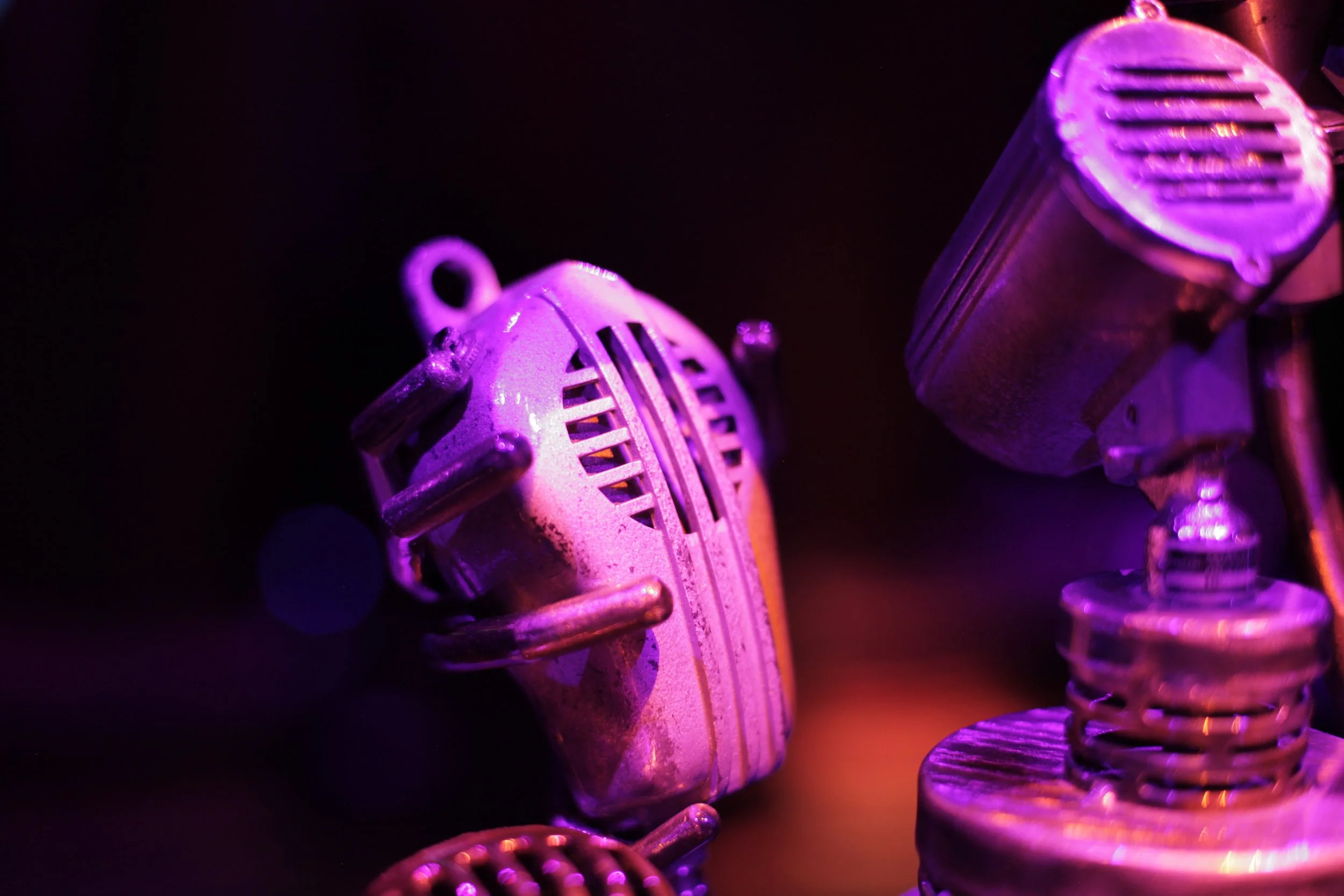 Close-up of vintage metallic microphones illuminated with purple and pink lighting in the Jazz club of Atlas9.