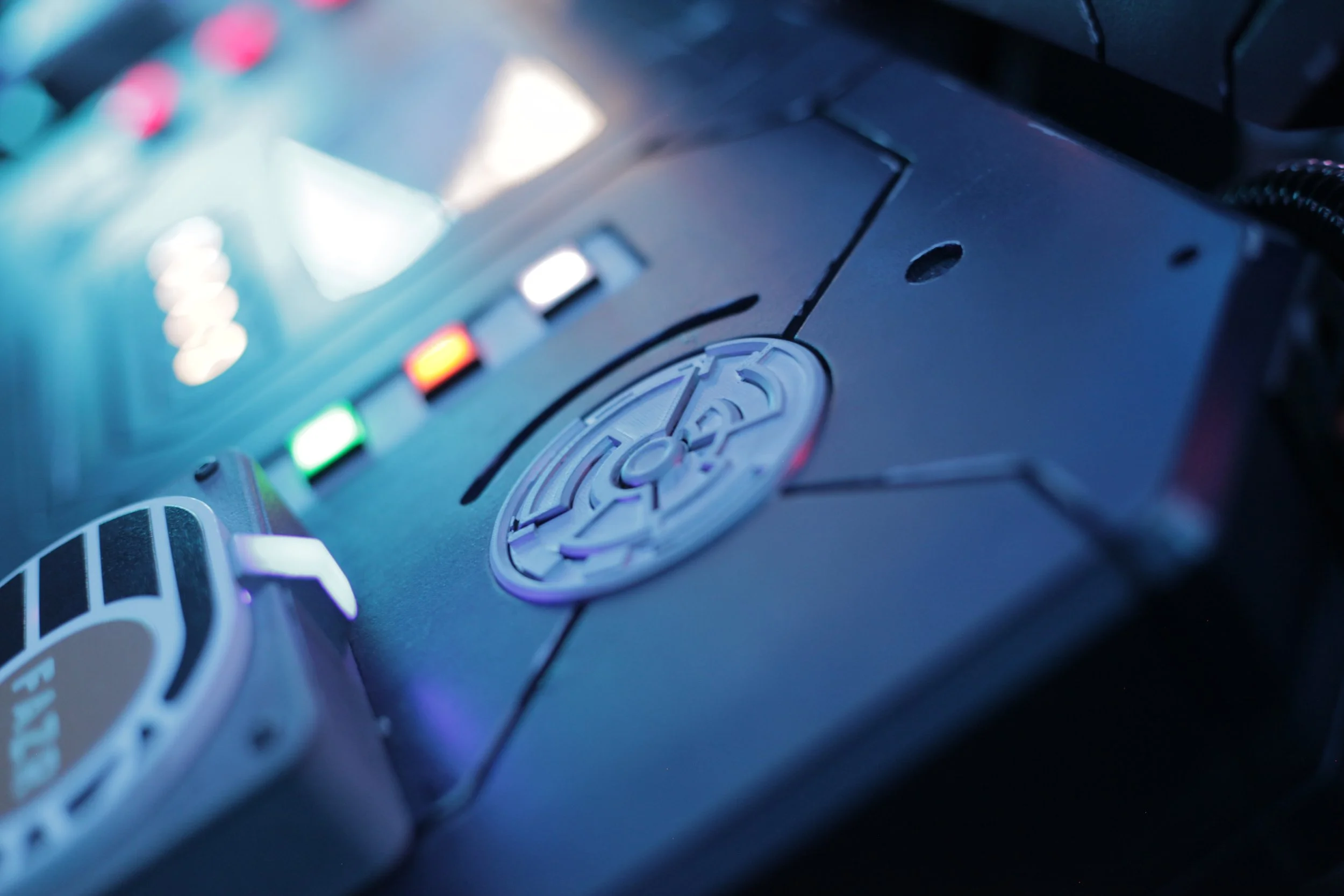 Close-up of a DJ turntable with colorful lights and a central control wheel.