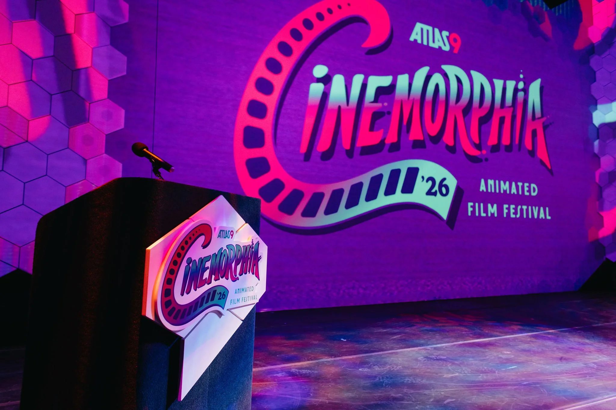 Stage with a backdrop inside Atlas9 displaying the logo and name of the 2026 Animation Film Festival, 'Cinemorphia,' with a podium in front featuring the same logo.