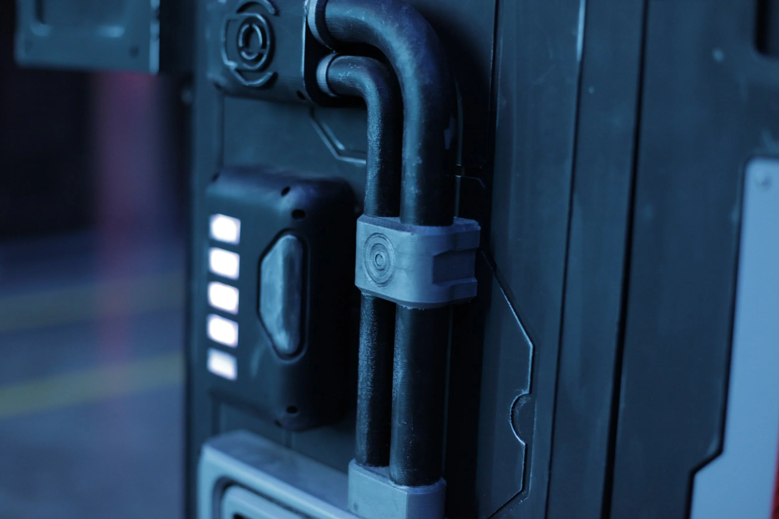 Close-up of a security lock on a server or electronic equipment, with cables and warning lights visible.