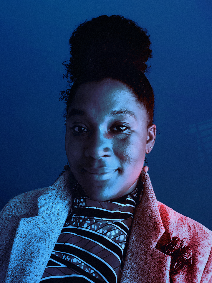 Ashanti gazing towards the camera, with blue and red hues lighting her face