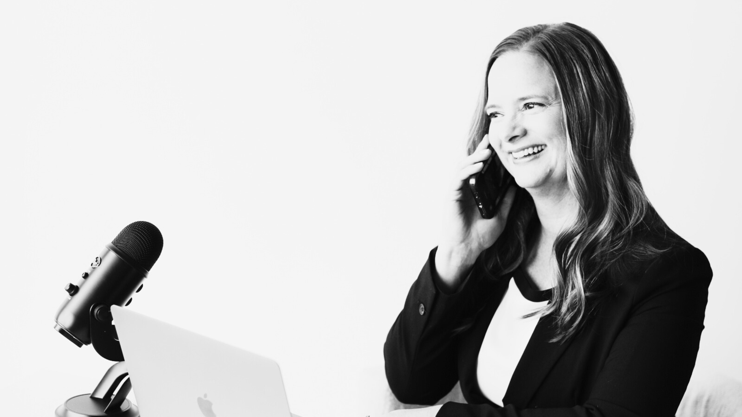 Jen Dunn on the phone, sitting at a desk in Calgary