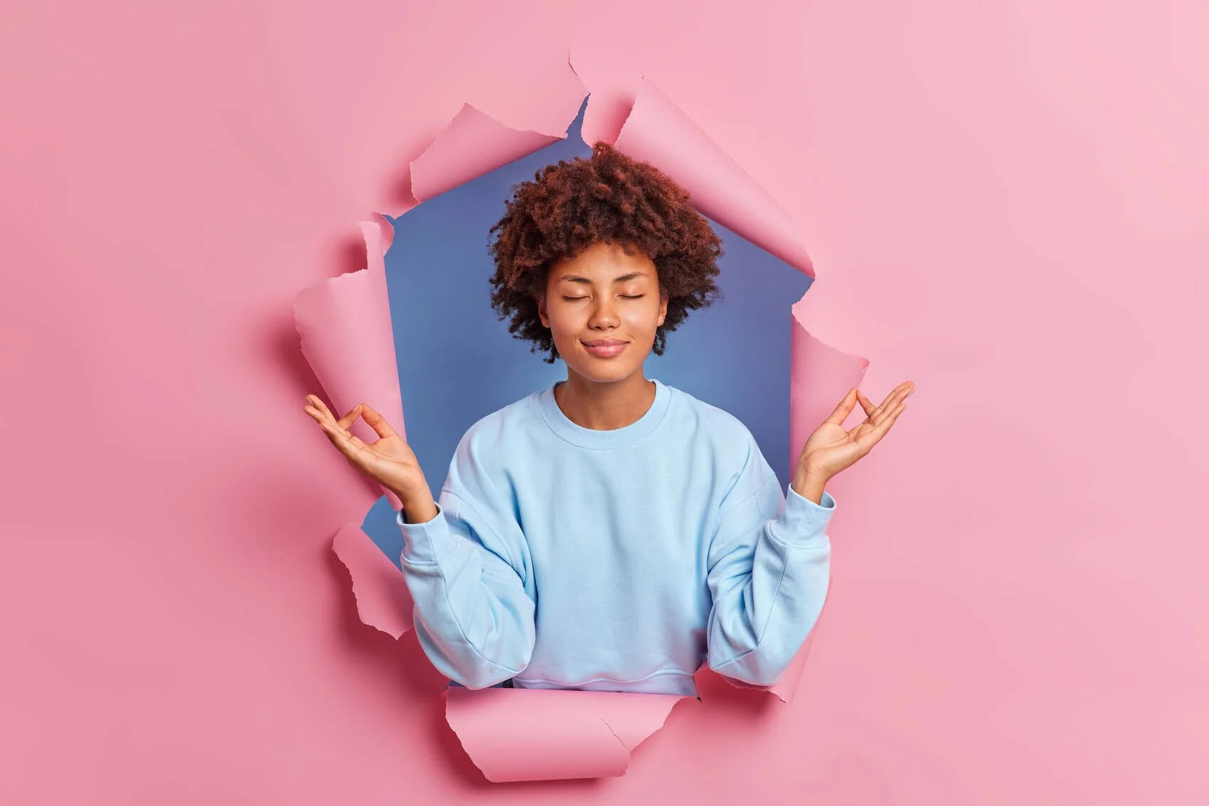 Young woman breaking through a sheet of pink paper - analogous to Transcranial magnetic stimulation