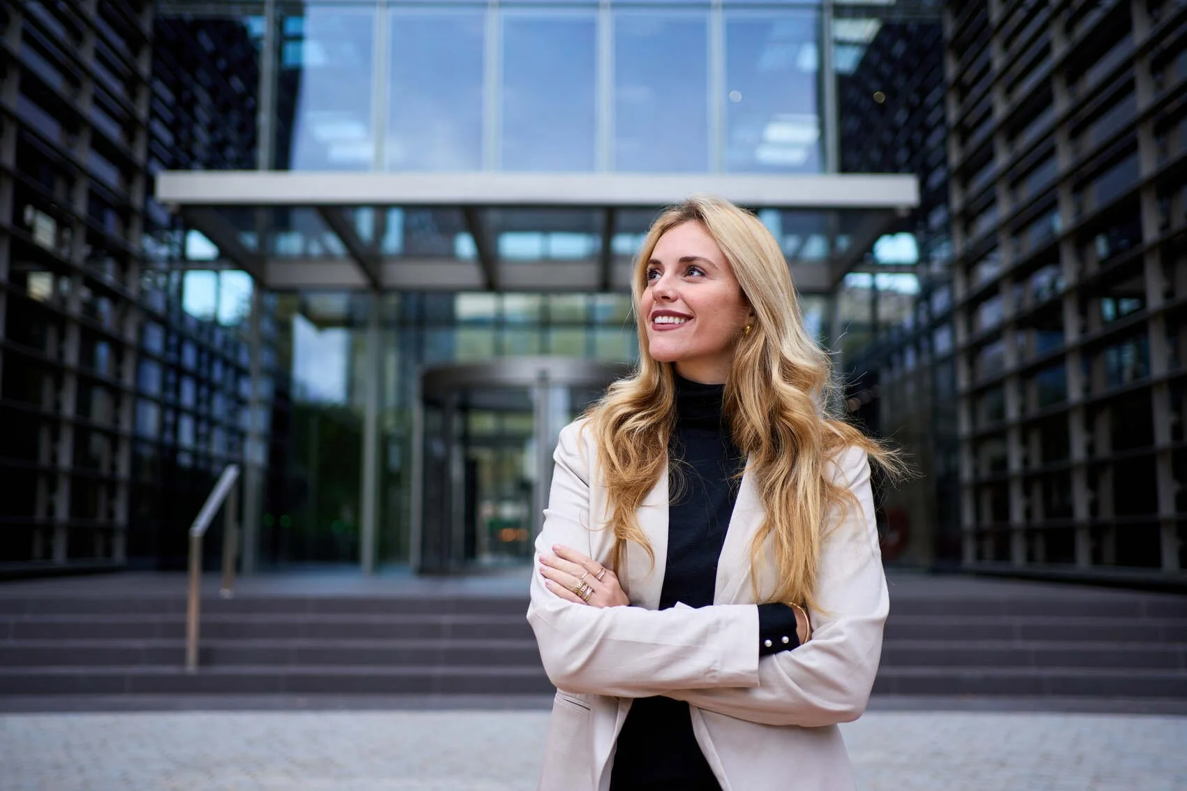 Smiling business woman standing outside of her work building in a city