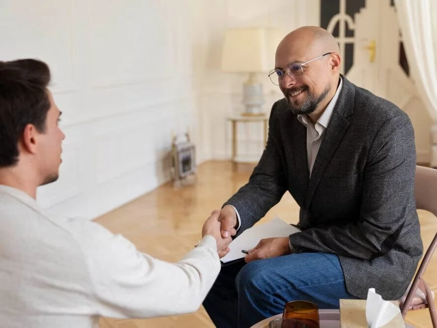 Professional man talking to male therapist in an office