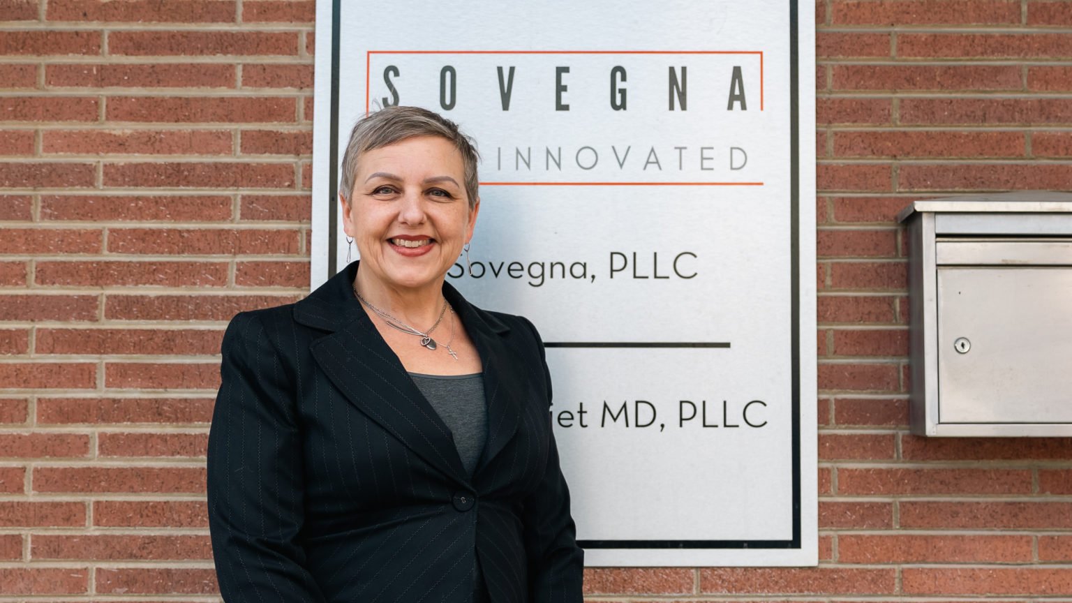 Dr. Susie Wiet standing outside next to sign for Sovegna
