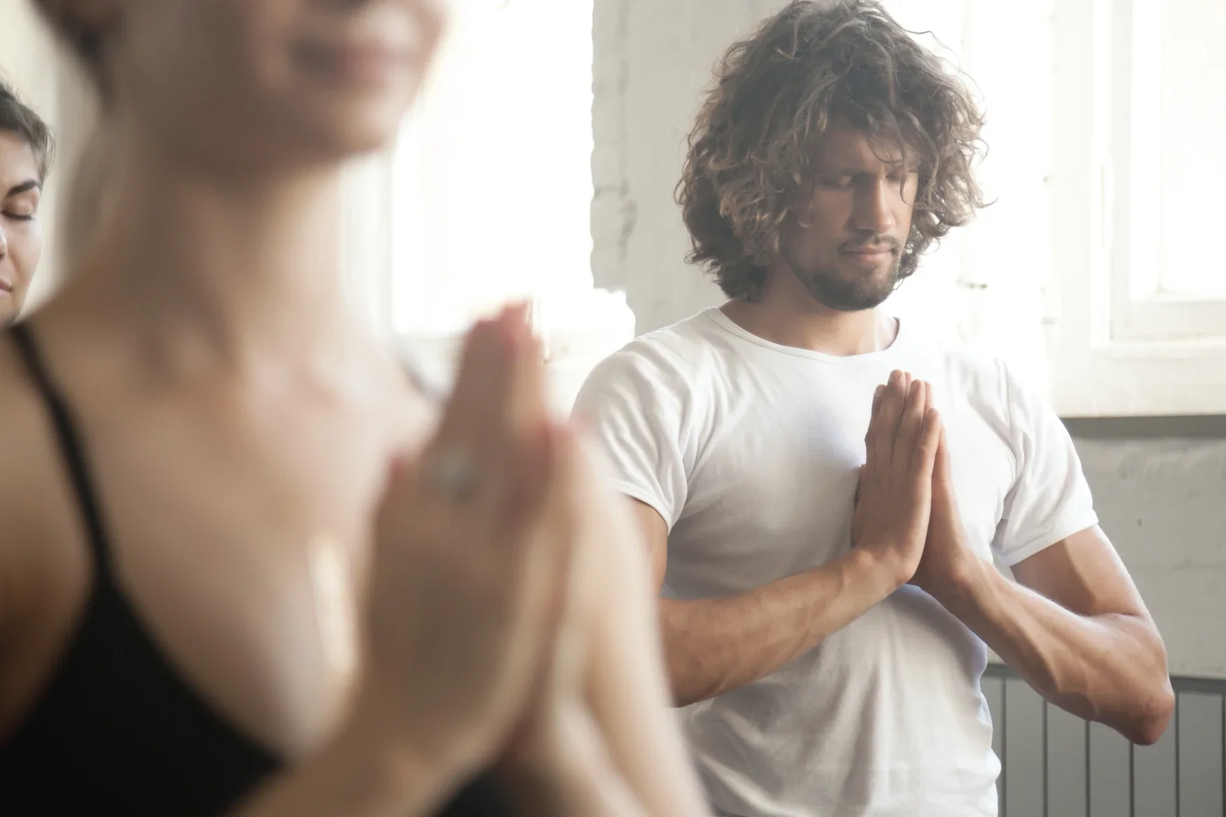 Male and female meditating in yoga class to improve mental heatlh